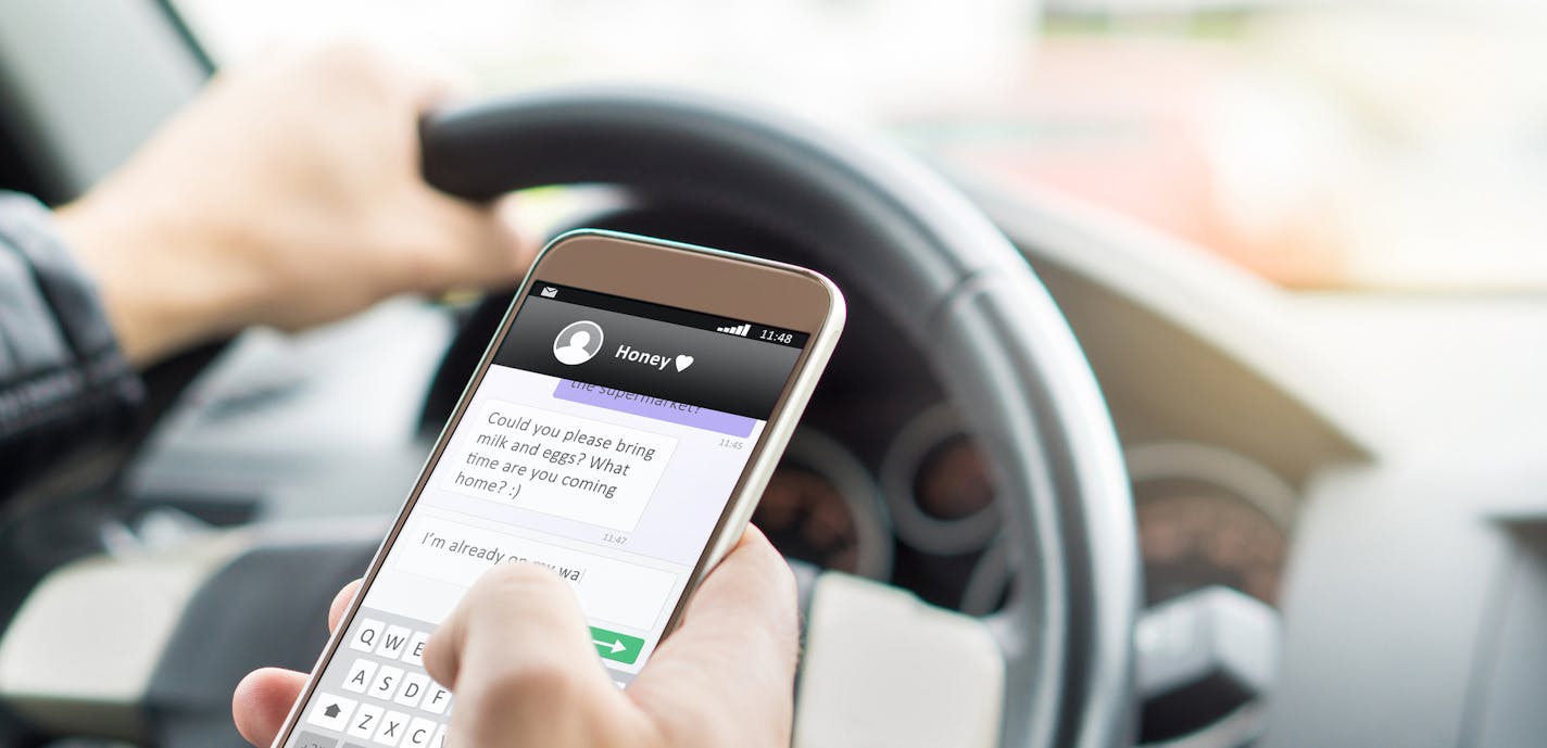 iStock
Texting while driving car. Irresponsible man sending sms and using smartphone. Writing and typing message with cellphone in vehicle.