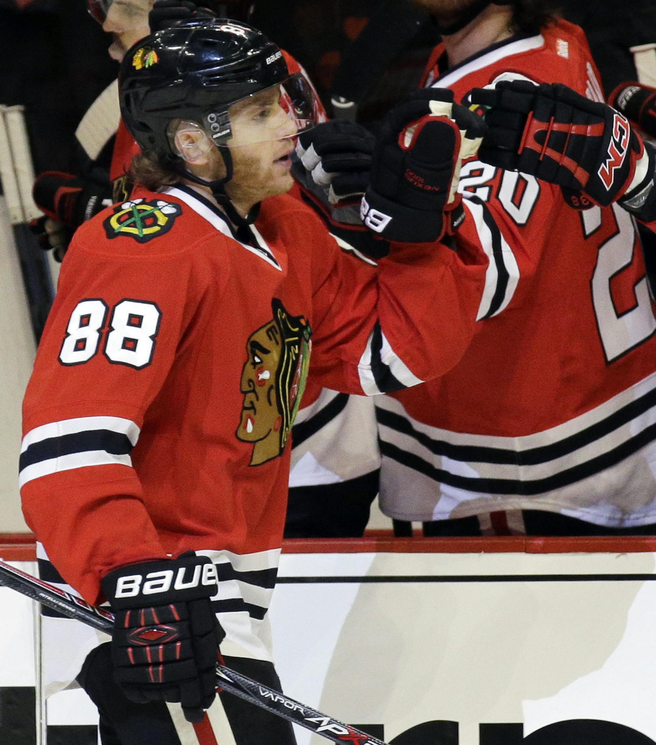 Chicago Blackhawks right wing Patrick Kane, left, celebrates with teammates after scoring his goal during the first period of Game 1 in the second round of the NHL Stanley Cup hockey playoffs against the Minnesota Wild in Chicago, Friday, May 1, 2015. (AP Photo/Nam Y. Huh)