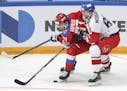 Russia's Kirill Kaprizov, center, and Czech Republic's Michal Moravcik battle for the puck during the Channel One Cup ice hockey match between Russia 