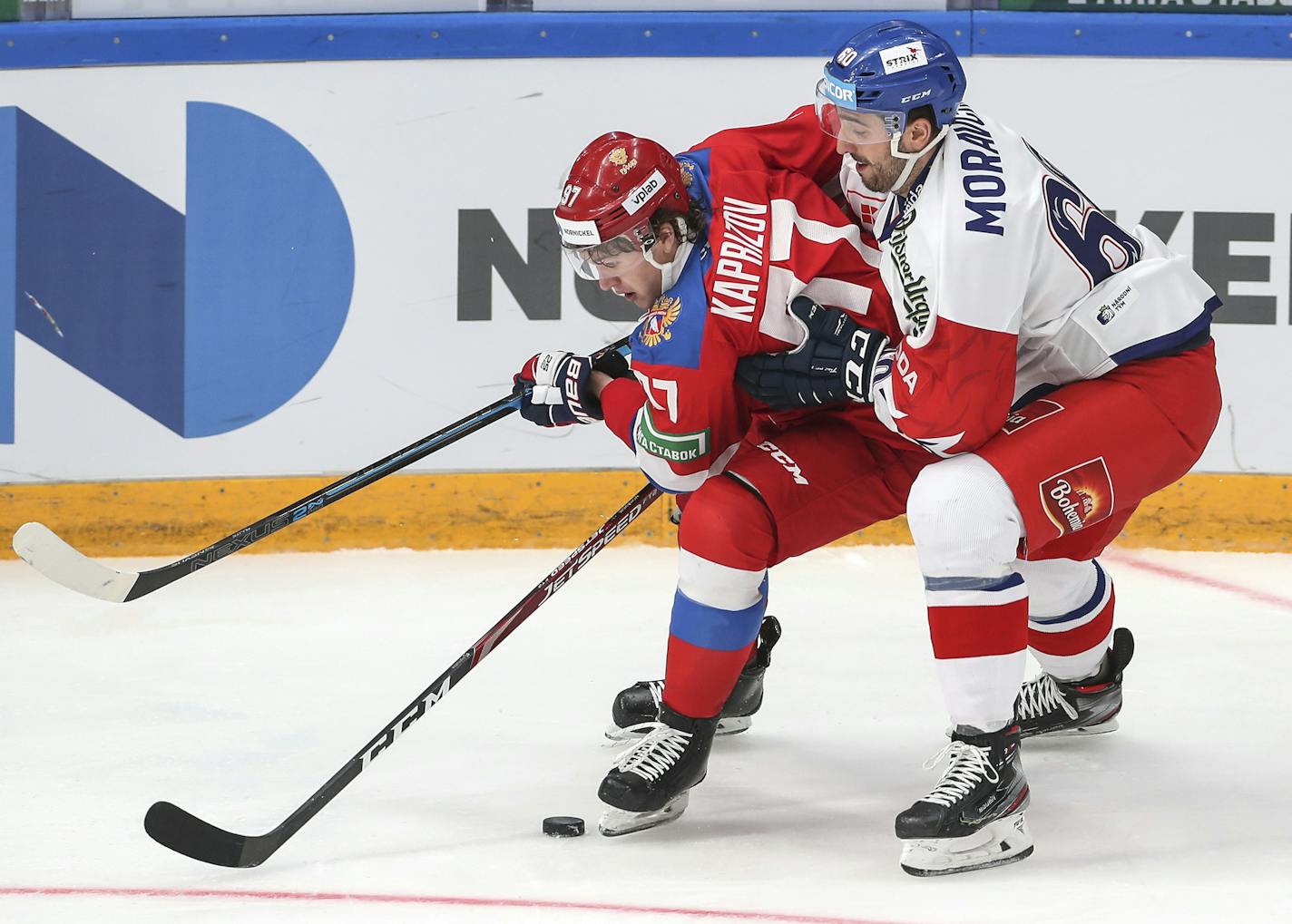 Russia's Kirill Kaprizov, center, and Czech Republic's Michal Moravcik battle for the puck during the Channel One Cup ice hockey match between Russia and Czech Republic in Moscow, Russia, Saturday, Dec. 14, 2019. (Alexander Safonov, Championat.com via AP)