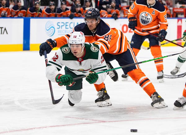 Minnesota Wild's Kevin Fiala (22) is checked by Edmonton Oilers' Philip Broberg (86) during third-period NHL hockey game action in Edmonton, Alberta, 