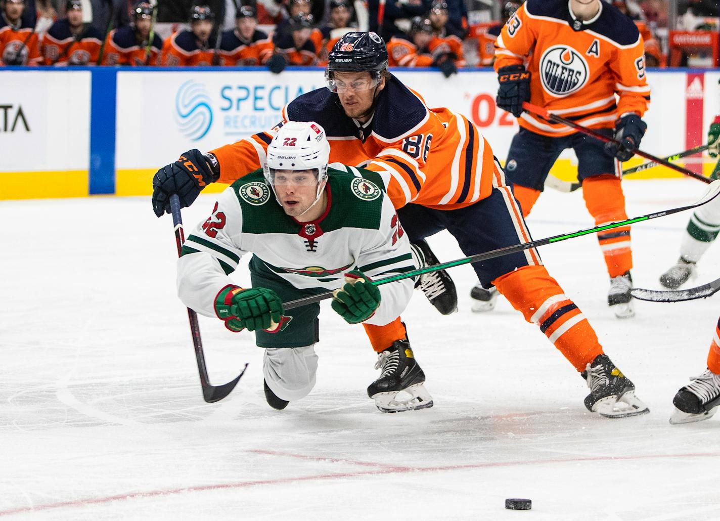 Minnesota Wild's Kevin Fiala (22) is checked by Edmonton Oilers' Philip Broberg (86) during third-period NHL hockey game action in Edmonton, Alberta, Sunday, Feb. 20, 2022. (Jason Franson/The Canadian Press via AP)