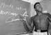 FILE - In this Nov. 15, 1962, file photo, young heavyweight boxer Cassius Clay, who later changed his name to Muhammad Ali, points to a sign he wrote 