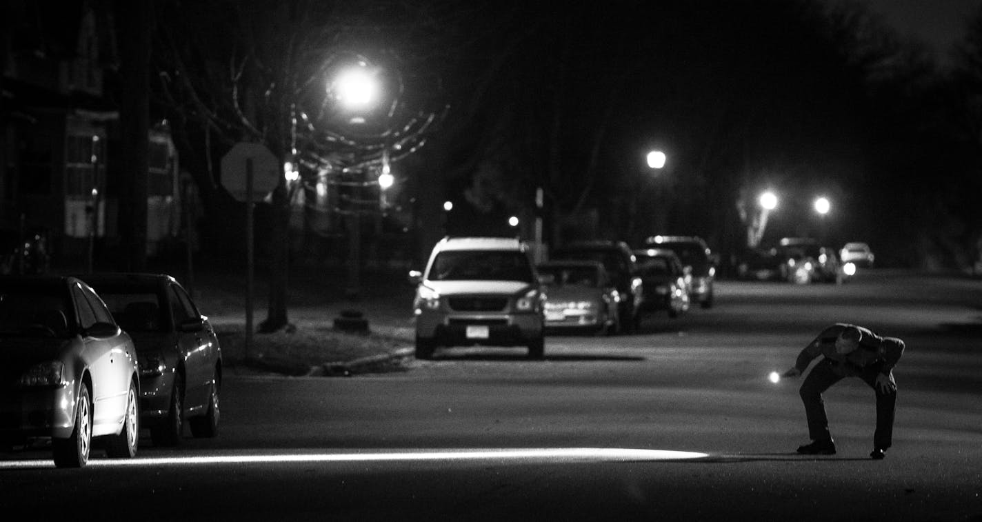 11:43 p.m. A St. Paul police officer checked the street for evidence on W. Taylor Avenue shortly after a double homicide at the Midway Motel on March 22.