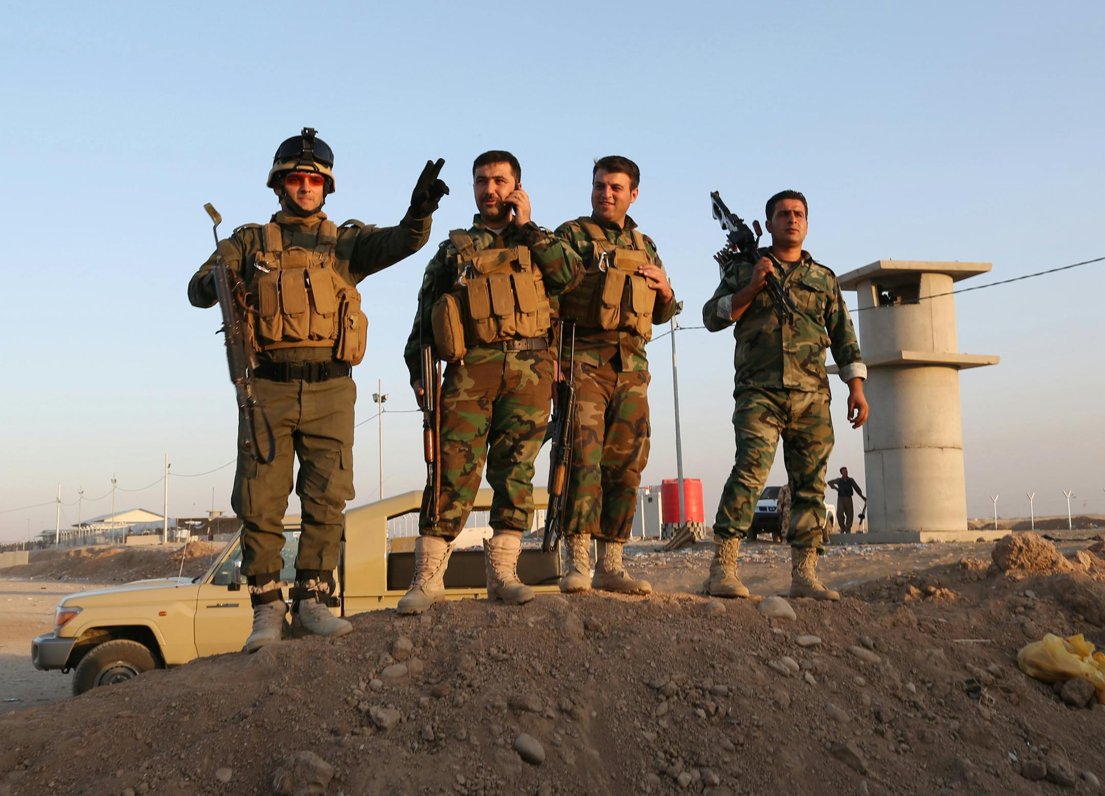 Kurdish Peshmerga fighters stand guard during airstrikes targeting Islamic State militants at the Khazer checkpoint outside of the city of Irbil in northern Iraq, Friday, Aug. 8, 2014. Iraqi Air Force has been carrying out strikes against the militants, and for the first time on Friday, U.S. war planes have directly targeted the extremist Islamic State group, which controls large areas of Syria and Iraq. (AP Photo/ Khalid Mohammed)