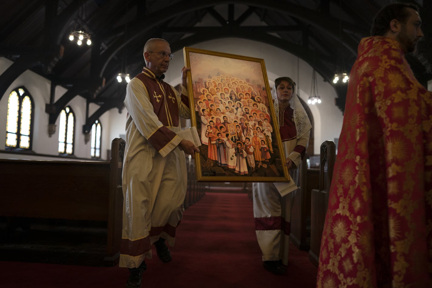 Jim Lippert left, and Lou Ann Matossian carried The icon of Holy Martyrs of the Armenian Genocide for a outdoor candle light service St. Sahag Armenian Church Wednesday April 24, 2019 in St. Paul, MN.] Opening ceremony for "Treasures of Memory & Hope "were held St. Sahag Armenian Church in St. Paul. The project features photographs by Artyom Tonoyan keeps alive the memory of 1.5 million Armenians killed a century ago. It features an exhibit of ordinary belongings from the extraordinary people wh