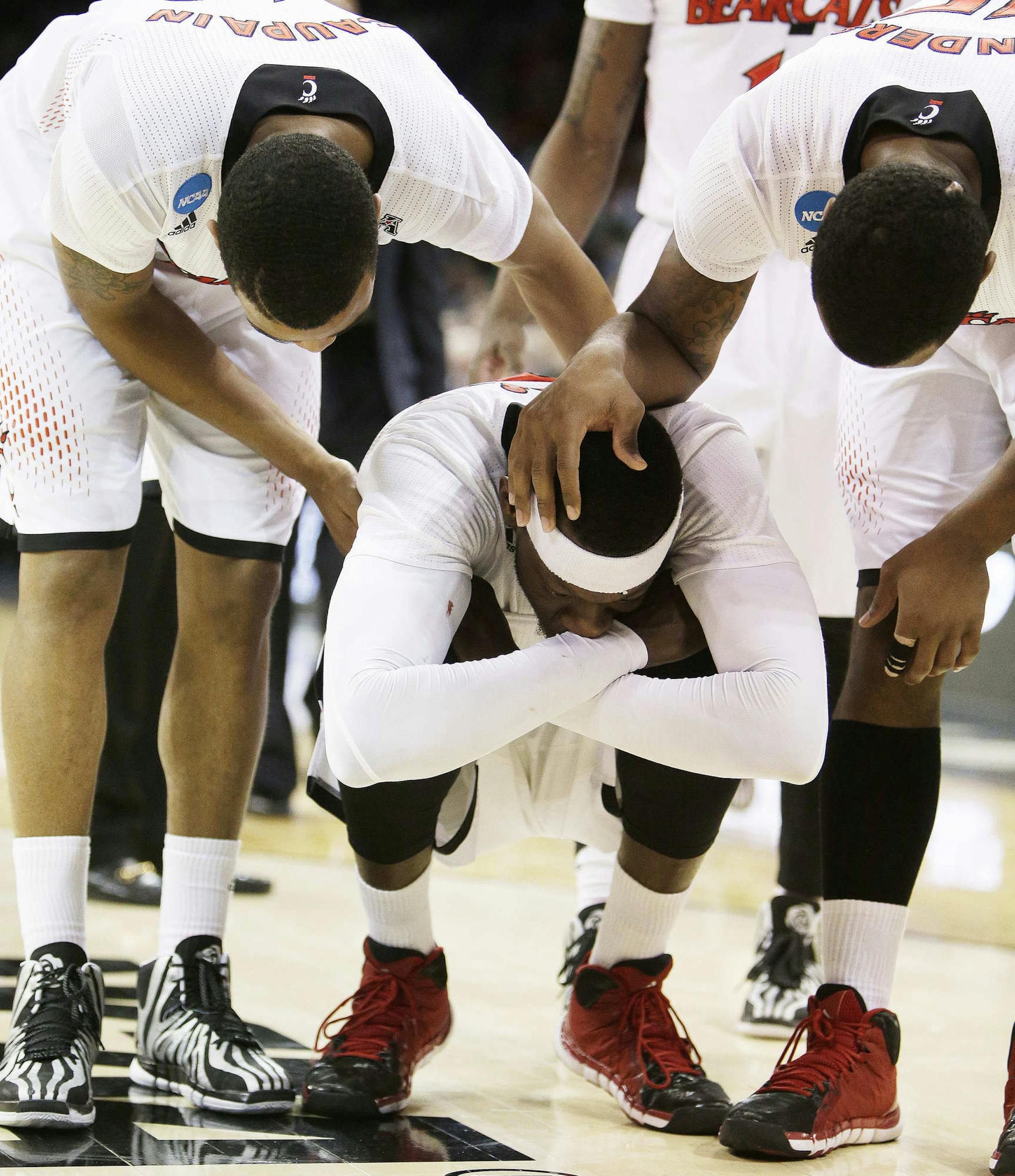 Cincinnati’s Troy Caupain, left, and Jermaine Sanders, right, speak with Justin Jackson after their 61-57 loss to Harvard in the second-round of the NCAA college basketball tournament in Spokane, Wash., Thursday, March 20, 2014. (AP Photo/Young Kwak)