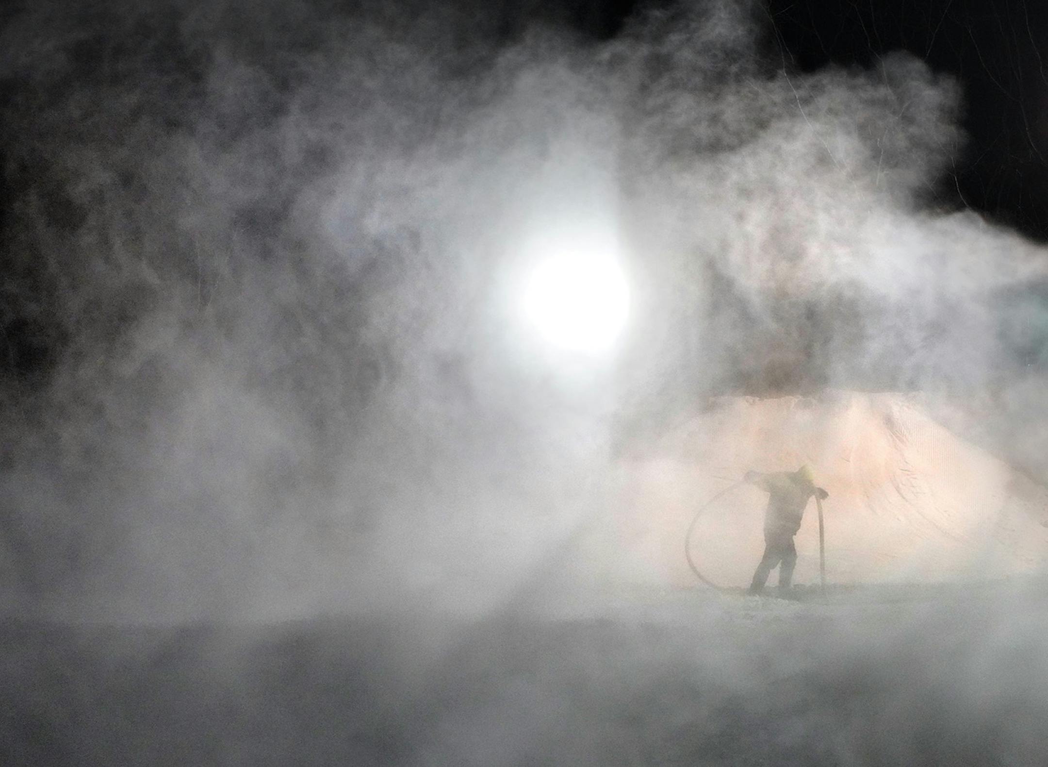 After the last skier had left the hill for the night, the crew at Hyland Hills Ski area in Bloomington got busy making more snow throughout the night. Here, Travis Peterson pulls a water hose out of a man-made blizzard at the top of Big Moe run. ] brian.peterson@startribune.com Bloomington, MN Tuesday, January 7, 2020