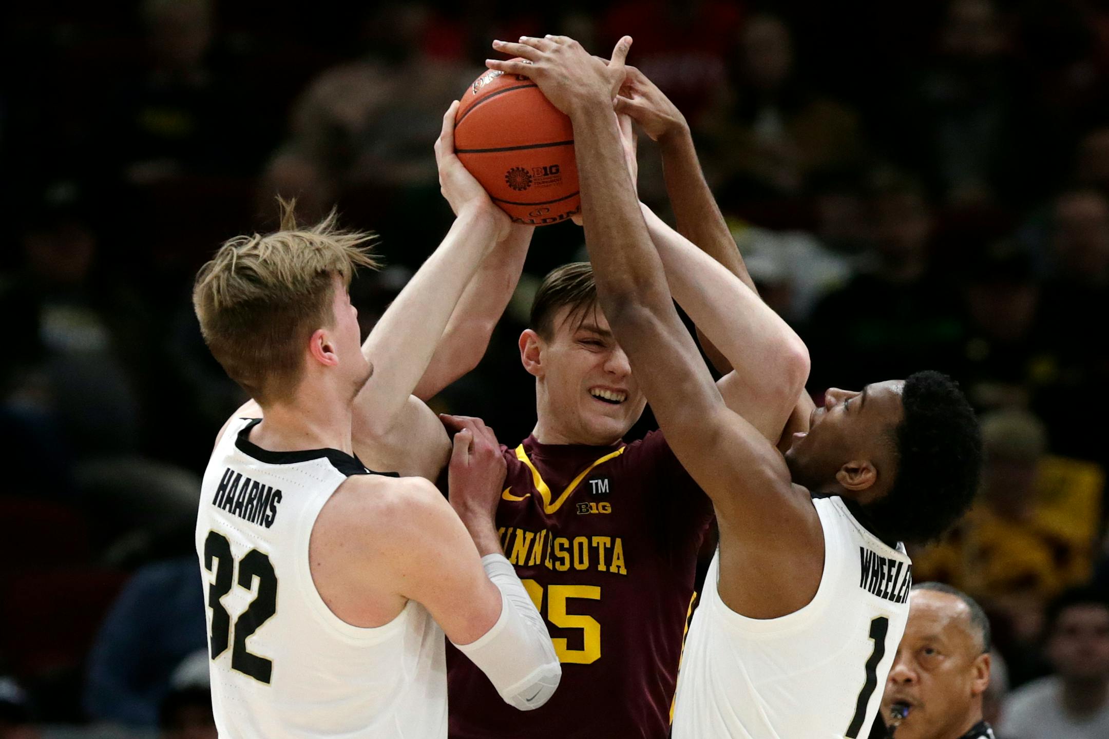 Minnesota's Matz Stockman (35) battles against Purdue's Matt Haarms (32) and Aaron Wheeler (1)