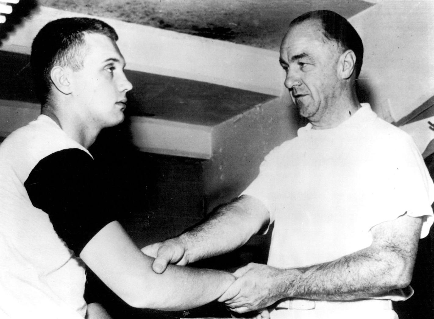 July 27, 1955 Heat Gets Gordy: Gordon Sundin, left, former Minneapolis Washburn athlete who signed a Baltimore contract Saturday, overdid things a bit Tuesday during a workout in 90-degree temperature and collapsed. Trainer Eddie Weidner is shown attending the stricken youngster. Sundin, a right-handed pitcher, was sent to the Orioles York, Pa., farm club yesterday. July 26, 1955 March 31, 1958 AP Wirephoto; Minneapolis Star Tribune