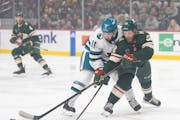 Wild right wing Ryan Hartman (38) passes to a teammate while defended by Sharks center Luke Kunin (11) in the first period Sunday.