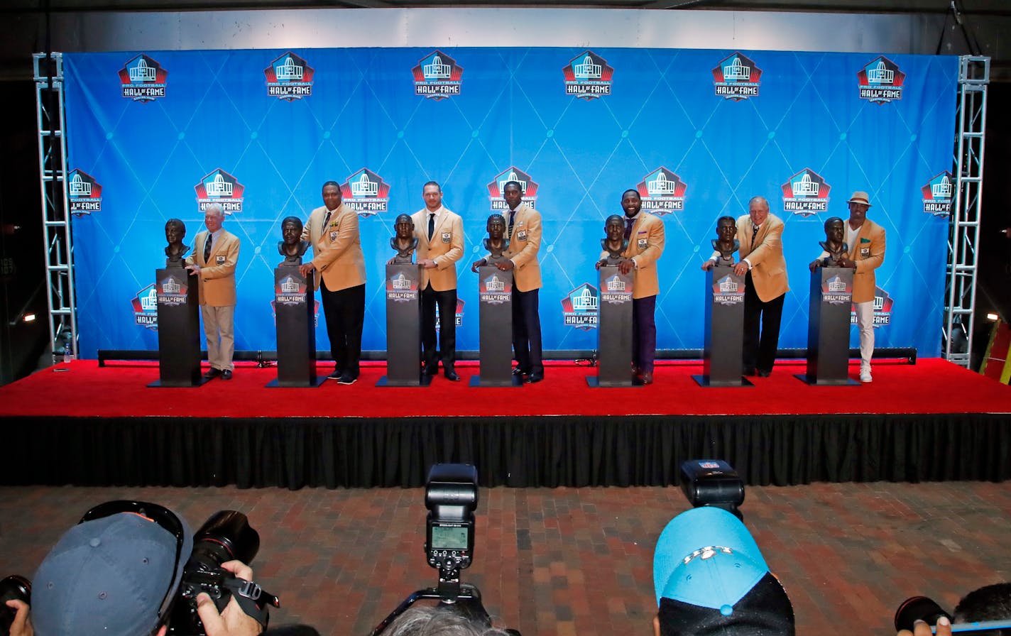 The Pro Football Hall of Fame class of 2018, minus Terrell Owens, poses with their busts following inductions at the hall, Saturday, Aug. 4, 2018, in Canton, Ohio. From left Bobby Beathard, Robert Brazile, Brian Urlacher, Randy Moss, Ray Lewis, Jerry Kramer and Brian Dawkins. (AP Photo/Gene J. Puskar)