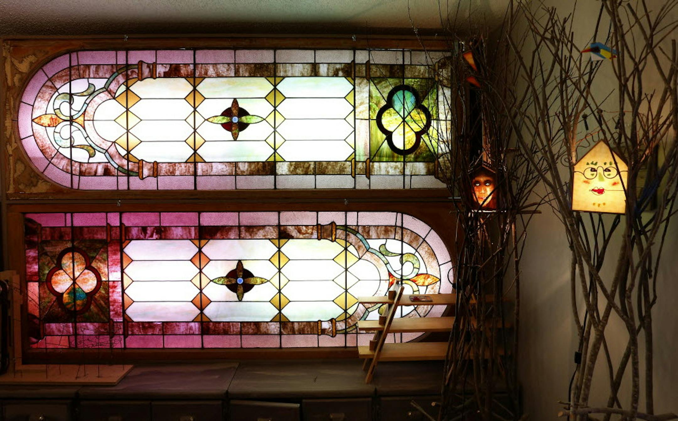Bob Calton restored old church windows and installed them in his condo’s entry, which also features some of his “willow women” creations.