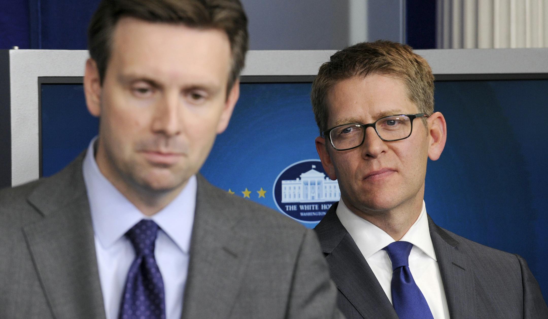 White House Press Secretary Jay Carney, right, listens as Principal Deputy Press Secretary Josh Earnest, left, answers a question during the daily briefing at the White House in Washington, Friday, May 30, 2014. President Barack Obama made a surprise visit at the briefing to announce that Carney will be stepping down and his successor will be Earnest. (AP Photo/Susan Walsh)