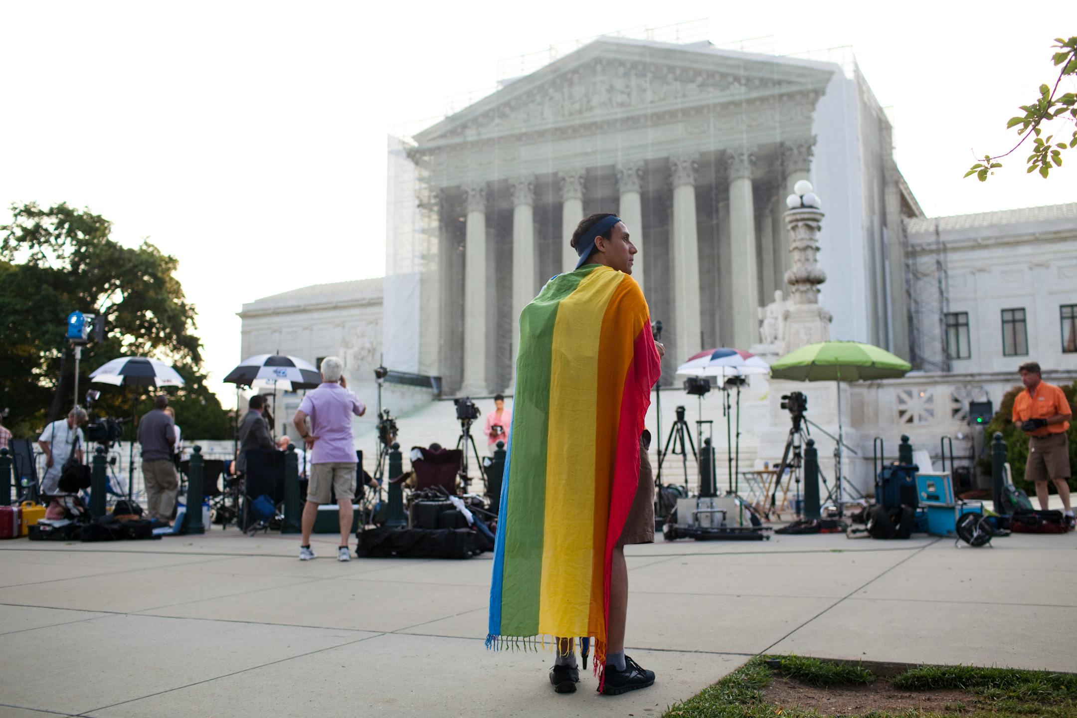 Oscar Soto wraps a rainbow flag around his shoulders while waiting for a ruling from the U.S. Supreme Court in Washington, June 26, 2013.