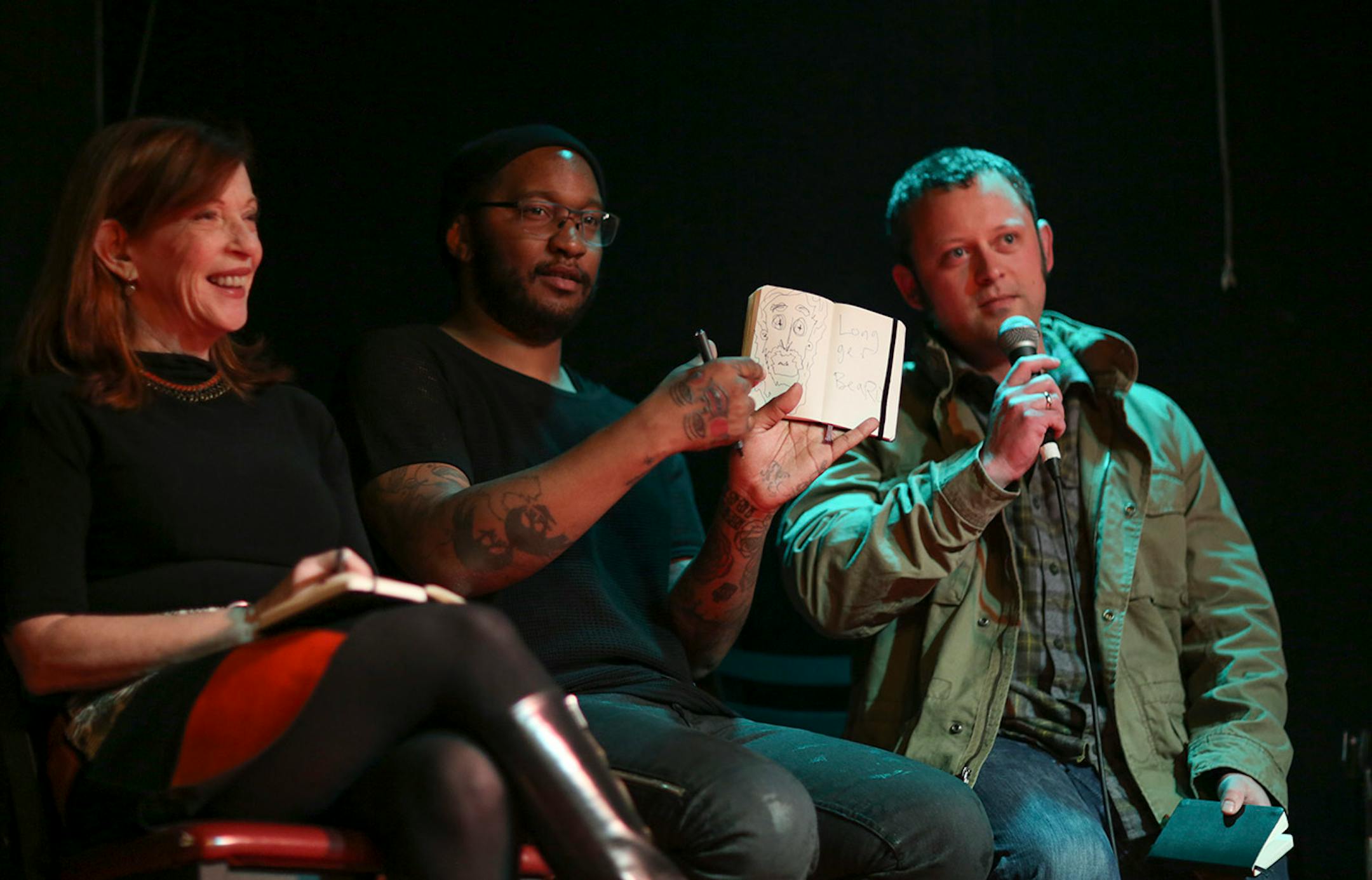 Judges Susan Orlean, Stefon Alexander, better known by his stage name P.O.S, and Benjamin Percy, from left, were the judges at the Literary Death Match Wednesday night at Nomad World Pub. Orlean is a New Yorker staff writer and author of the Orchid Thief. Alexander, tasked with judging each reader's performance, is a founding member of the local hip hop collective Doomtree. He was holding up a drawing he did of Mark Doten, the winner of the second round of competition. Percy is the author of The