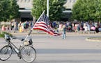 Joldy Wynen of Minneapolis, who rode her bike from Minneapolis, photographed her bike with the flag before the start of the Lights for Liberty vigil "
