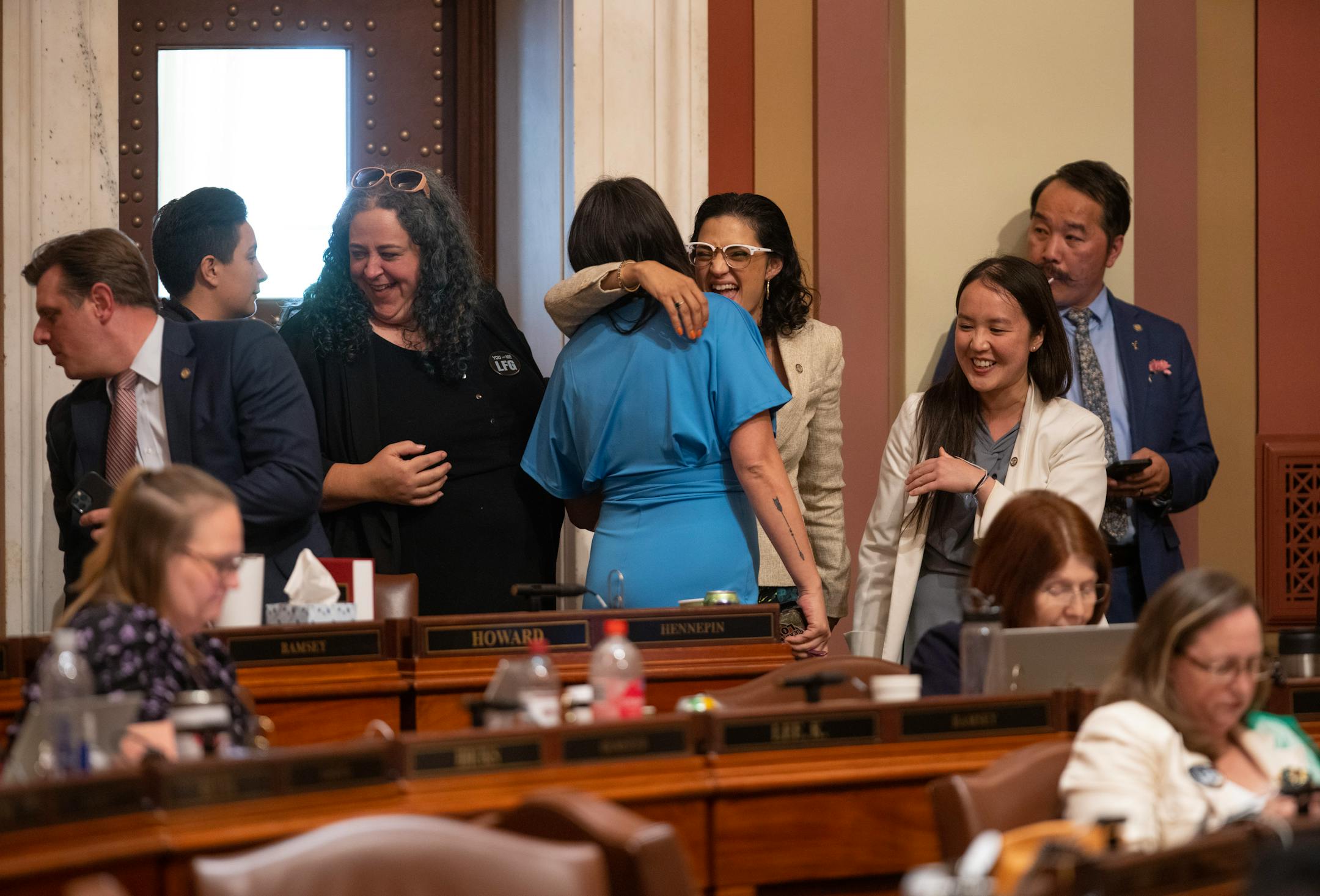 María Isa Pérez-Vega, DFL, 65B, St. Paul, center, was congratulated by Heather Keeler, DFL, 4A, Moorhead, back to camera, after she spoke in support of the Health and Human Services finance bill on the floor of the house Monday evening.
