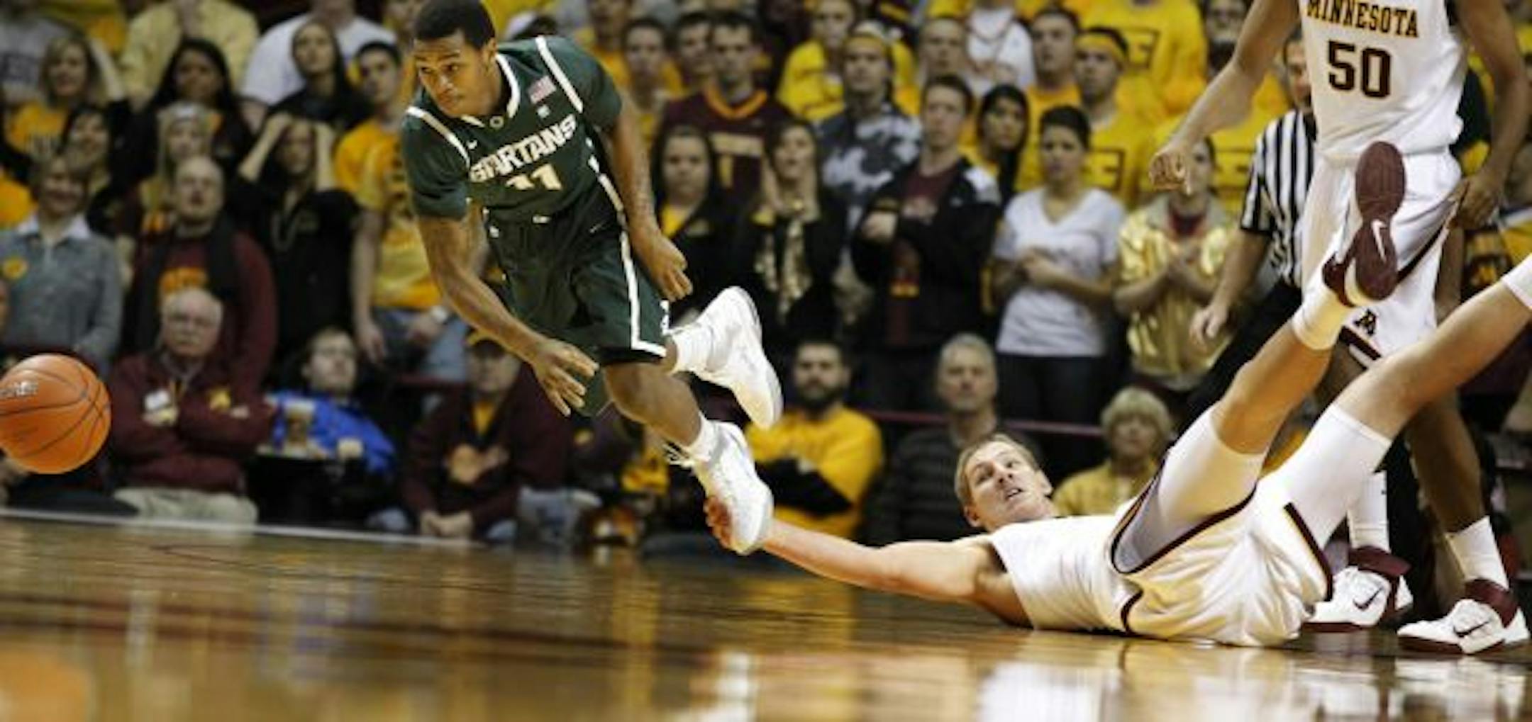 Michigan State's Keith Appling went after a loose ball as the Gophers' Colton Iverson grabbed his foot during the Spartans' 53-48 victory over the Gophers on Tuesday.
