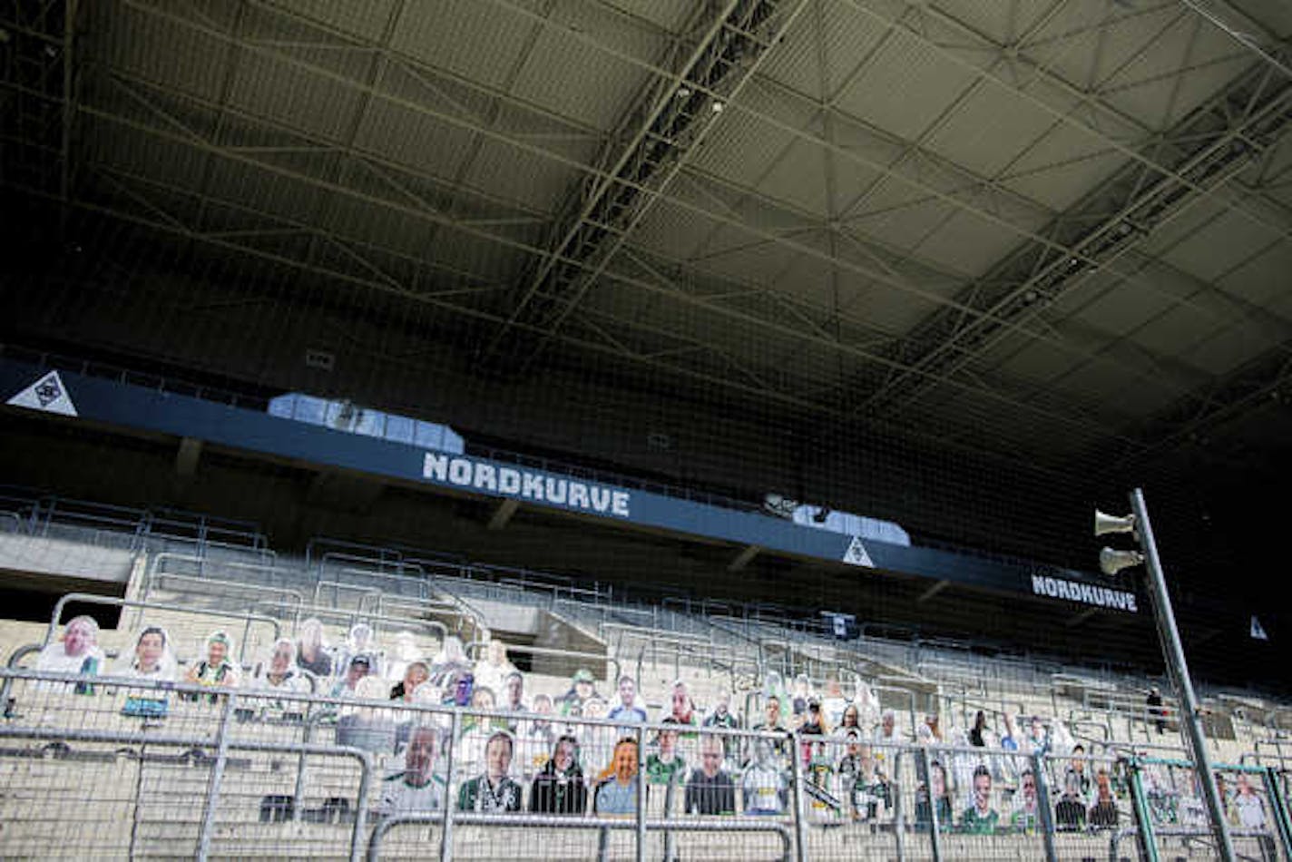 Members of supporters club fix the first "cardboard comrades" of soccer club Borussia Moenchengladbach on Thursday in the stadium in Moenchengladbach, Germany. The fans of Gladbach want to contribute to a better atmosphere at possible ghost games in the German Bundesliga.