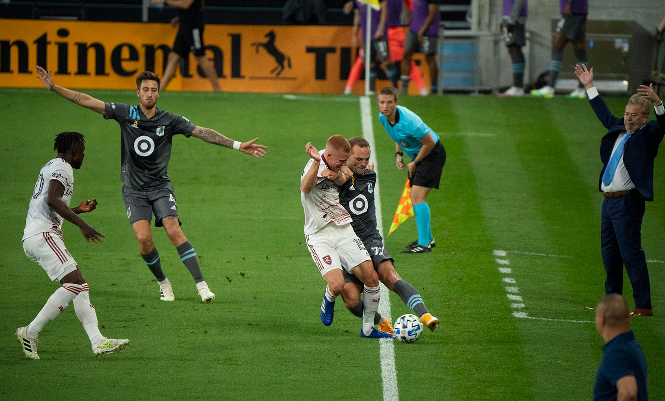 Minnesota United defender Chase Gasper (77) tried to keep the ball inbounds despite the efforts of Real Salt Lake defender Justen Glad (15) in the first half. At right is Loons head coach Adrian Heath.