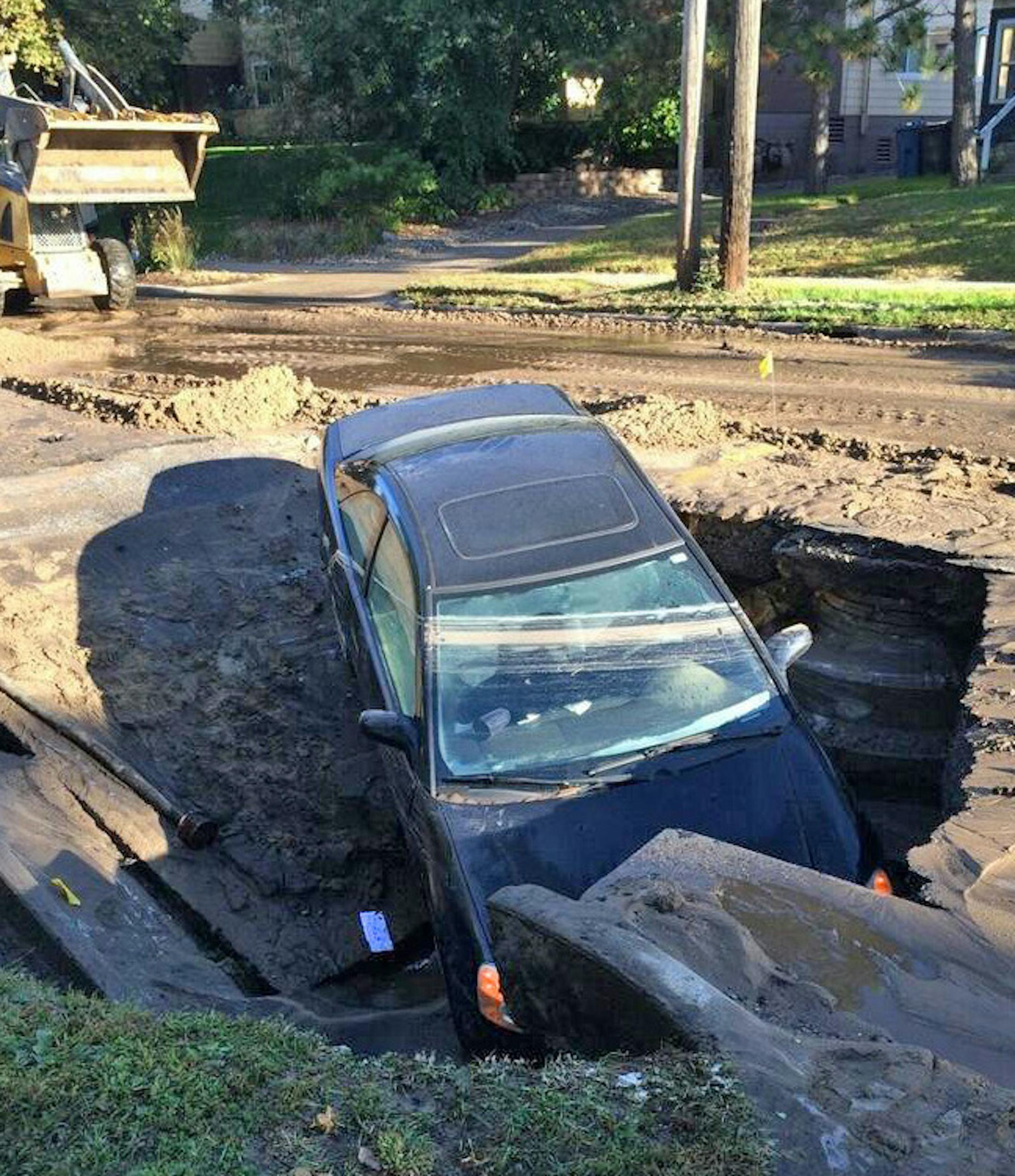 A water main broke under a neighborhood street in southeast Minneapolis over the weekend, sending a portion of the pavement into collapse and leaving a parked car partly submerged. The break of the pipe, 8 inches in diameter, occurred Sunday in the 400 block of 8th Street SE., according to city spokesman Matt Lindstrom. Water service was restored that afternoon, but the block is off limits for ìa few daysî until temporary repairs are made, Lindstrom said. Credit: Special to the Star Tr