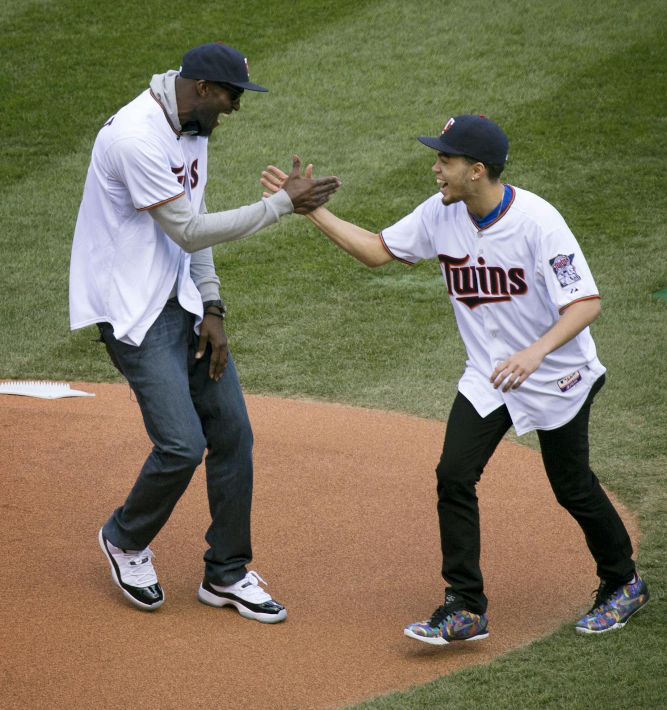 Timberwolves Kevin Garnett and Duke Star and former Apple Valley High School basketball player Tyus Jones shake hands on the mound after Garnett threw out the first pitch at the Minnesota Twins Home Opener Monday afternoon at Target Field.