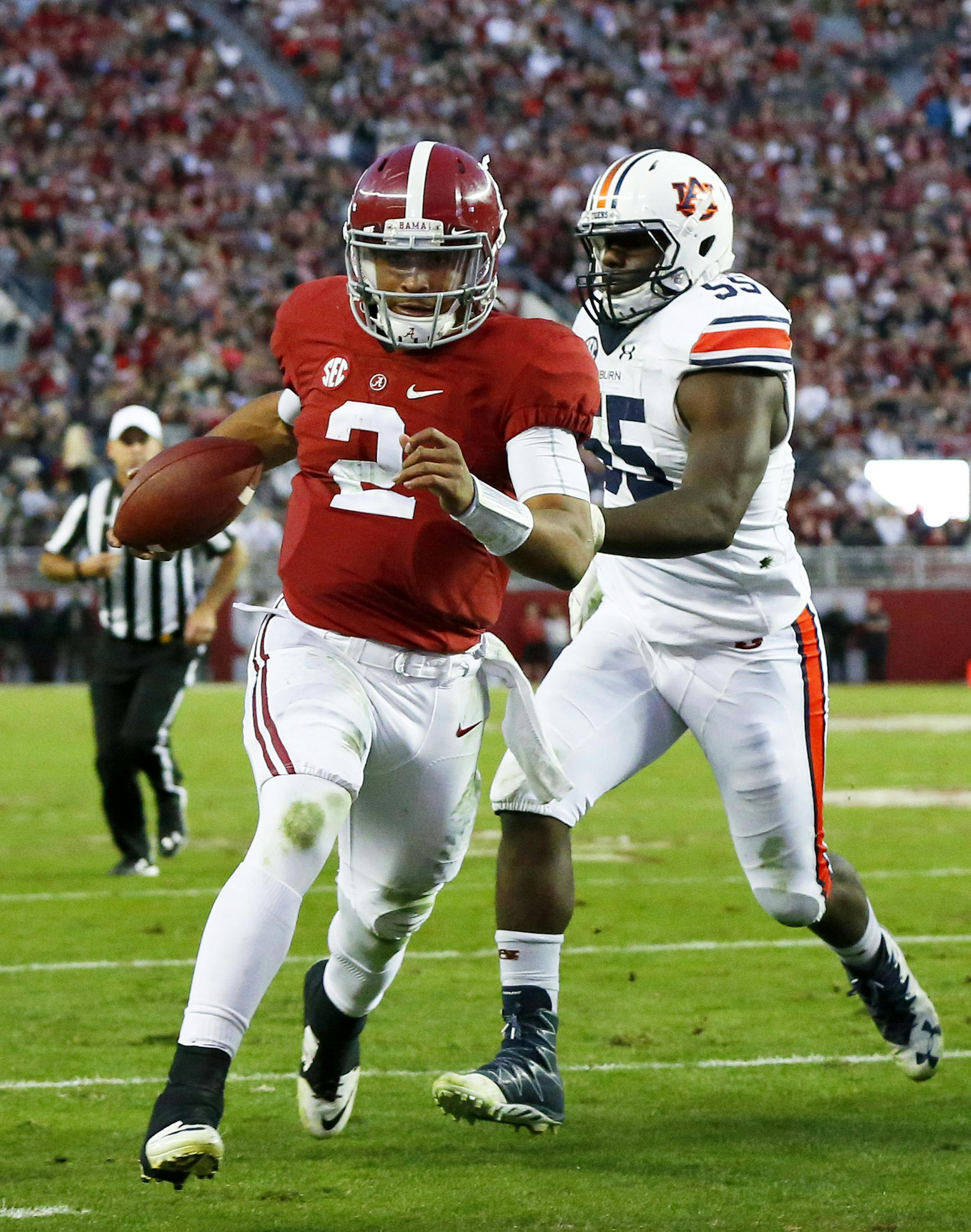 Alabama quarterback Jalen Hurts runs in to score a touchdown against Auburn defensive lineman Carl Lawson during the first half of the Iron Bowl NCAA college football game, Saturday, Nov. 26, 2016, in Tuscaloosa, Ala. (AP Photo/Butch Dill)