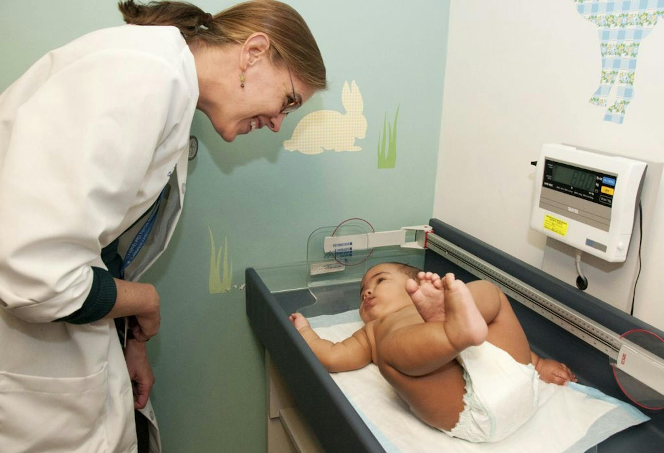 In this photo taken Oct. 3, 2011, Dr. Claire McCarthy looks down as an infant�s growth is measured during a check-up at Children�s Hospital Boston.