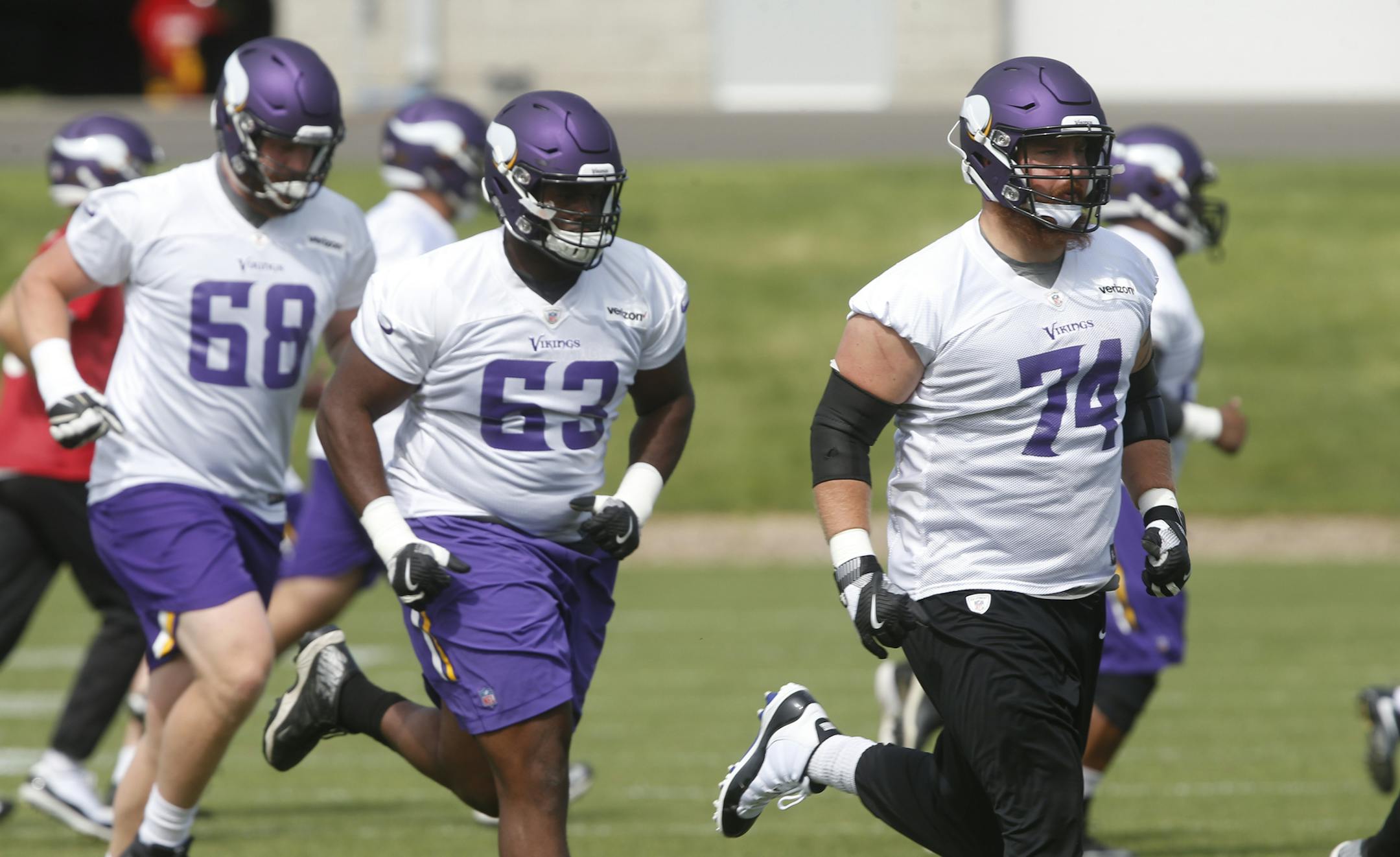 Minnesota Vikings tackles Mike Remmers (74), Cedrick Lang (68) and guard Danny Isidora (63) jog to another drill during practice at the NFL football team's training camp in Eagan, Minn., Thursday, June 14, 2018. (AP Photo/Jim Mone)