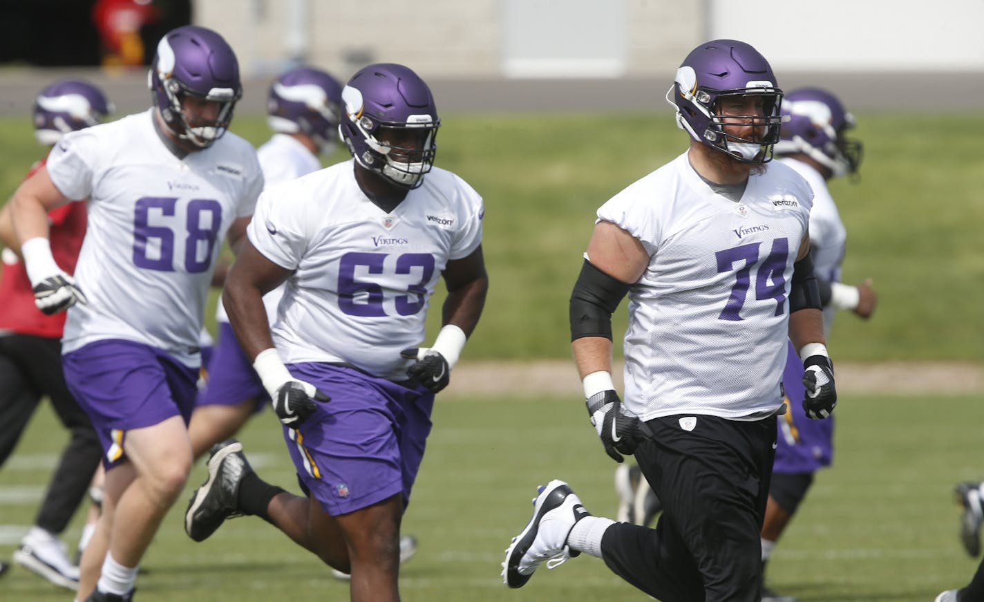 Minnesota Vikings tackles Mike Remmers (74), Cedrick Lang (68) and guard Danny Isidora (63) jog to another drill during practice at the NFL football team's training camp in Eagan, Minn., Thursday, June 14, 2018. (AP Photo/Jim Mone)