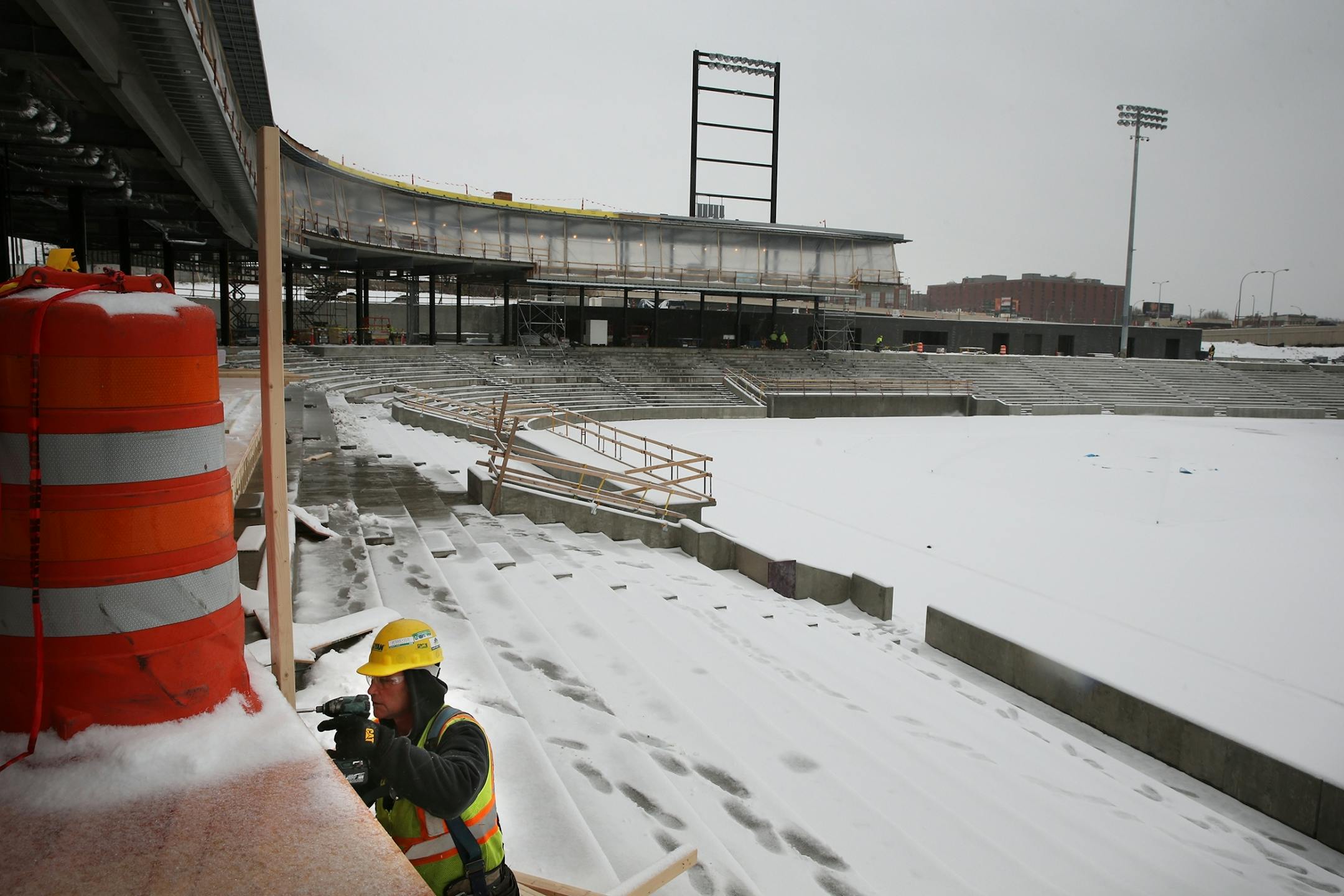 A Ryan Construction worker named Rick, who did not want his last name used, drills boards into place at the Lowertown Ballpark construction site in St. Paul during the first snowstorm of the season on Monday, November 10, 2014.