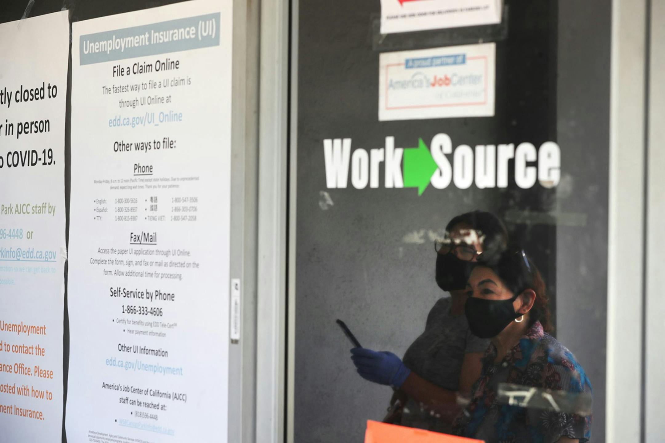In this file photo, Estella Flores, right, and Maria Mora, left, are reflected in a window as they look for information in front of the closed California State Employment Development Department on Thursday, May 14, 2020 in Canoga Park, CA. Expanded unemployment-insurance benefits have given concrete support to U.S. personal incomes during the pandemic. (Brian van der Brug/Los Angeles Times/TNS) ORG XMIT: 1700865