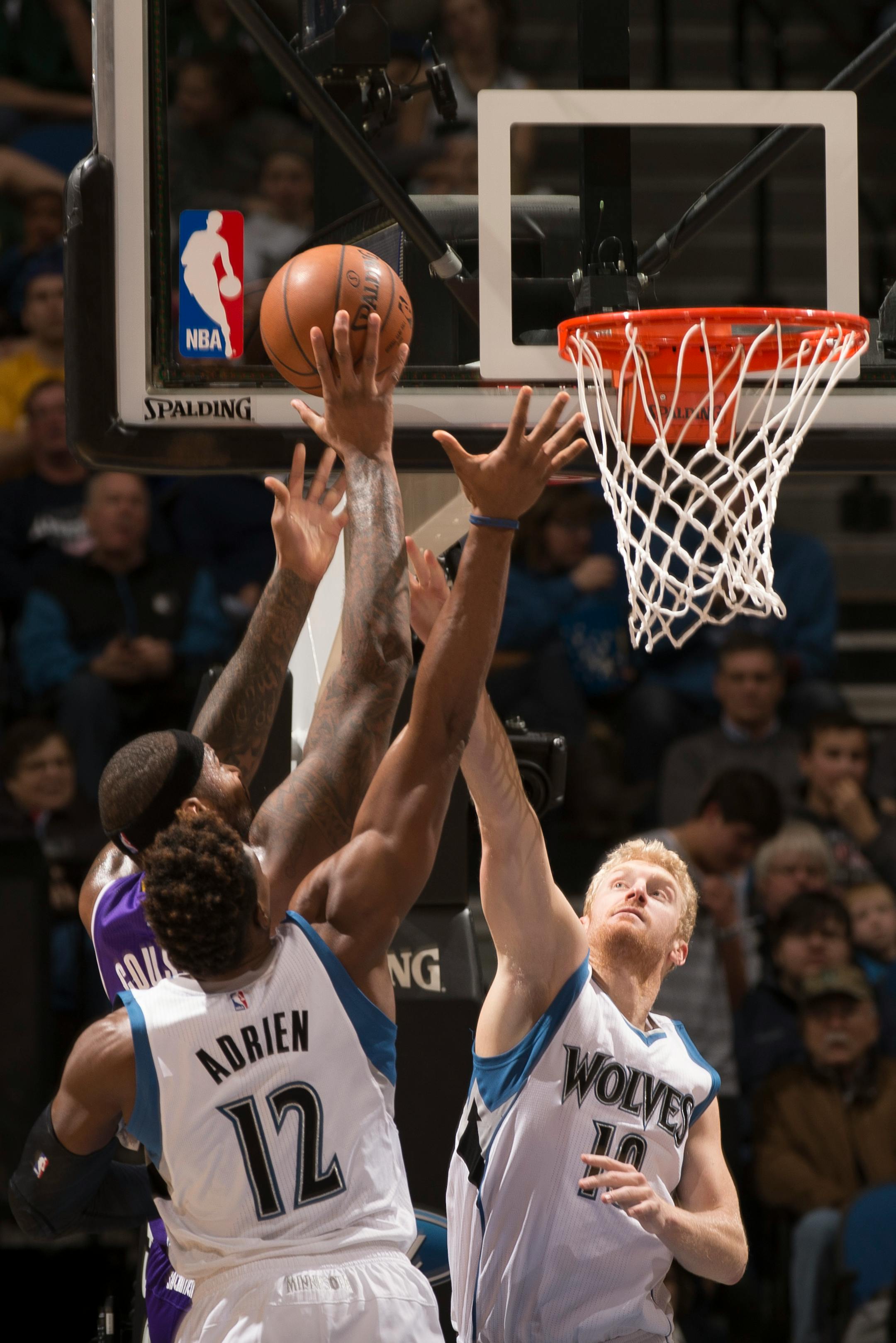 Minnesota Timberwolves forward Chase Budinger (10) and forward Jeff Adrien (12) defend against a shot by Sacramento Kings center DeMarcus Cousins (15) during the second quarter.