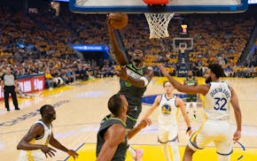 Timberwolves guard Anthony Edwards (5) shoots around Golden State Warriors forward Trayce Jackson-Davis (32) in the first half in Game 3 of their NBA