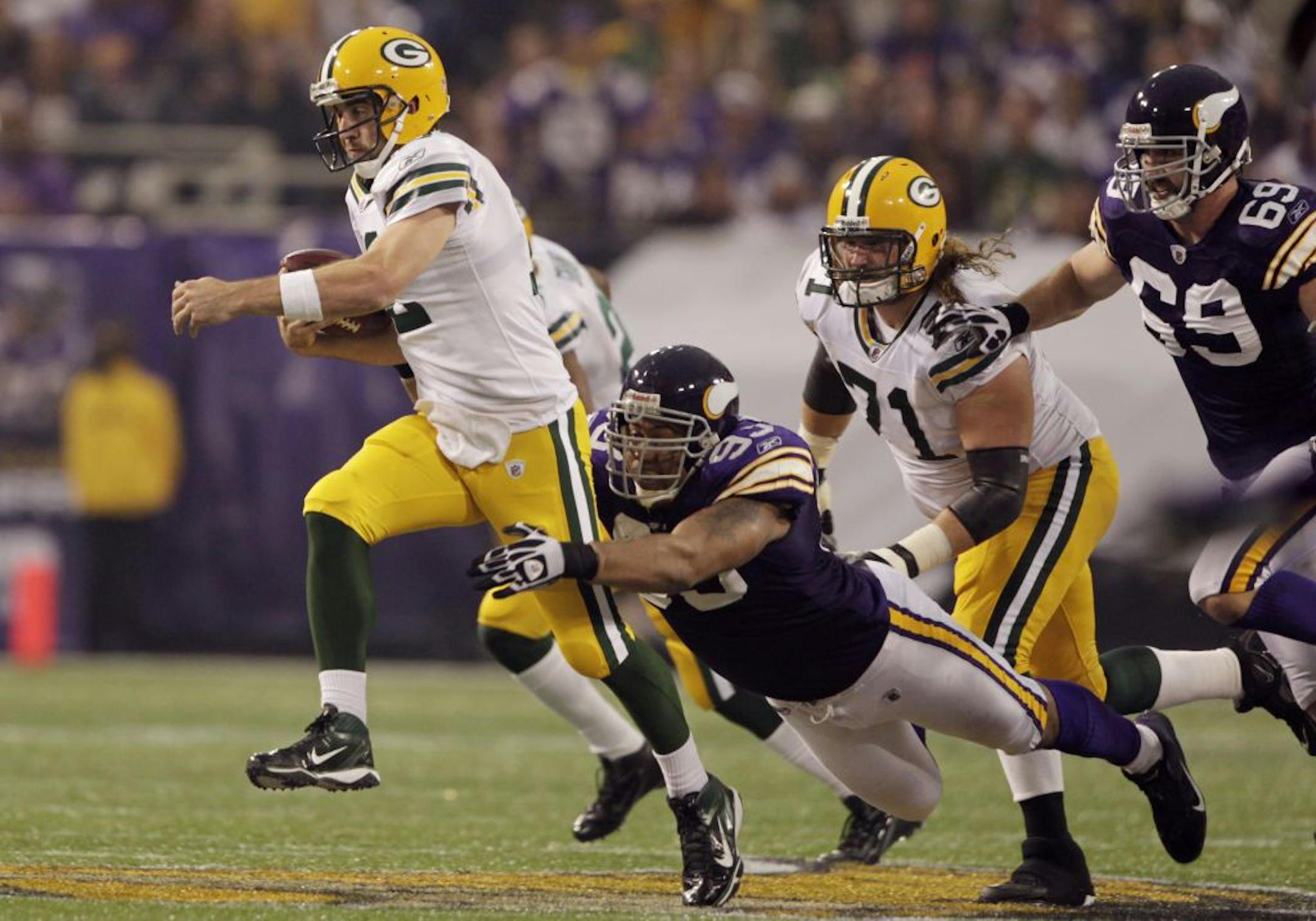 Green Bay's quarterback Aaron Rodgers breaks a tackle on Vikings Kevin Williams.