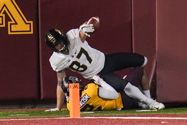 Purdue tight end Payne Durham (87) made a catch against Gophers defensive back Phillip Howard (2) but was flagged for pass interference in the key pla