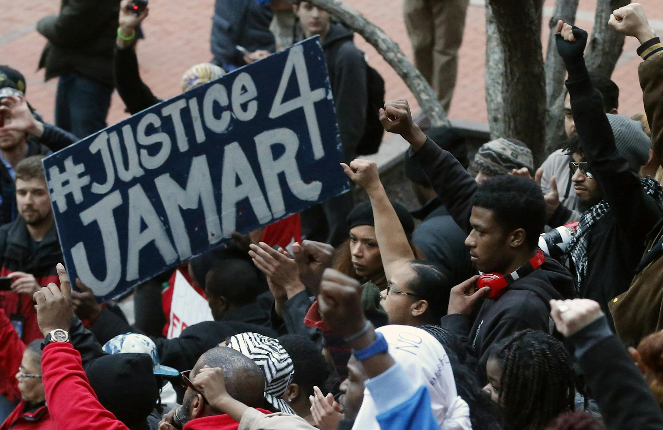 FILE - In this March 30, 2016 photo, demonstrators raise their fists in the air at the Government Center in Minneapolis during a protest over two Minneapolis police officers fatally shooting Jamar Clark, a black man, in November 2015. Two Minneapolis police officers followed proper procedure in a confrontation that led to the fatal shooting of Clark in November, and won't face discipline, the city's police chief announced Friday, Oct. 21. (AP Photo/Jim Mone, File) ORG XMIT: MIN2016102511353212