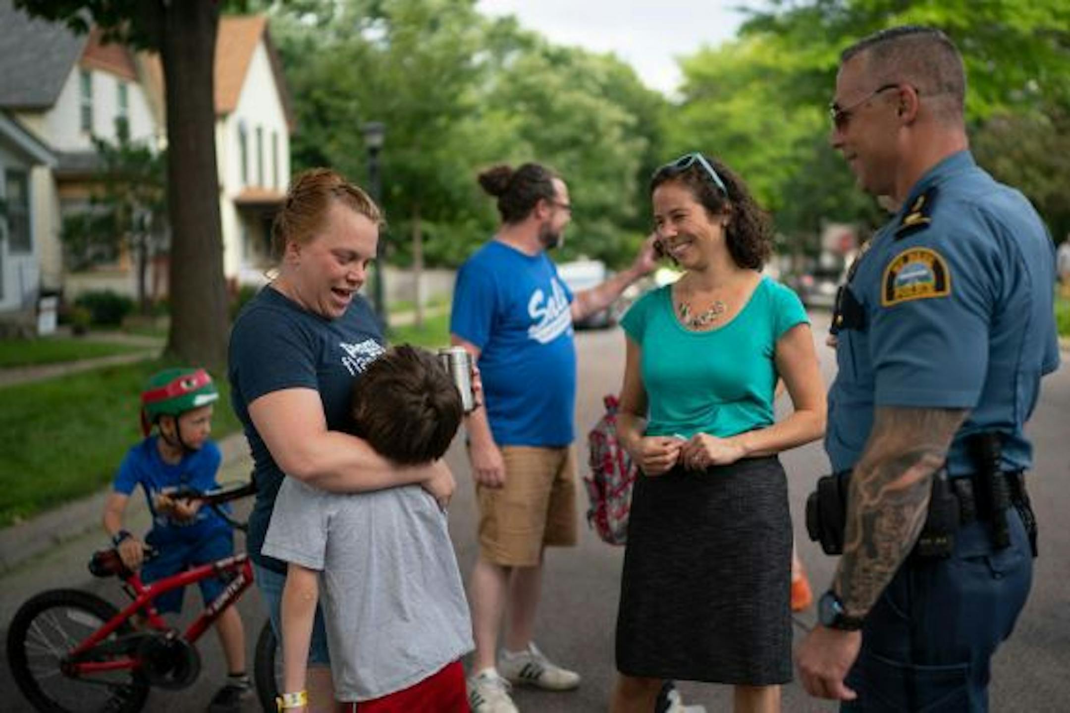 Rebecca Penforl-Murray hugged her son, Peter, while visiting with St. Paul City Council Member Rebecca Noecker and St. Paul Police Commander Wes Denning at National Night Out in 2019.