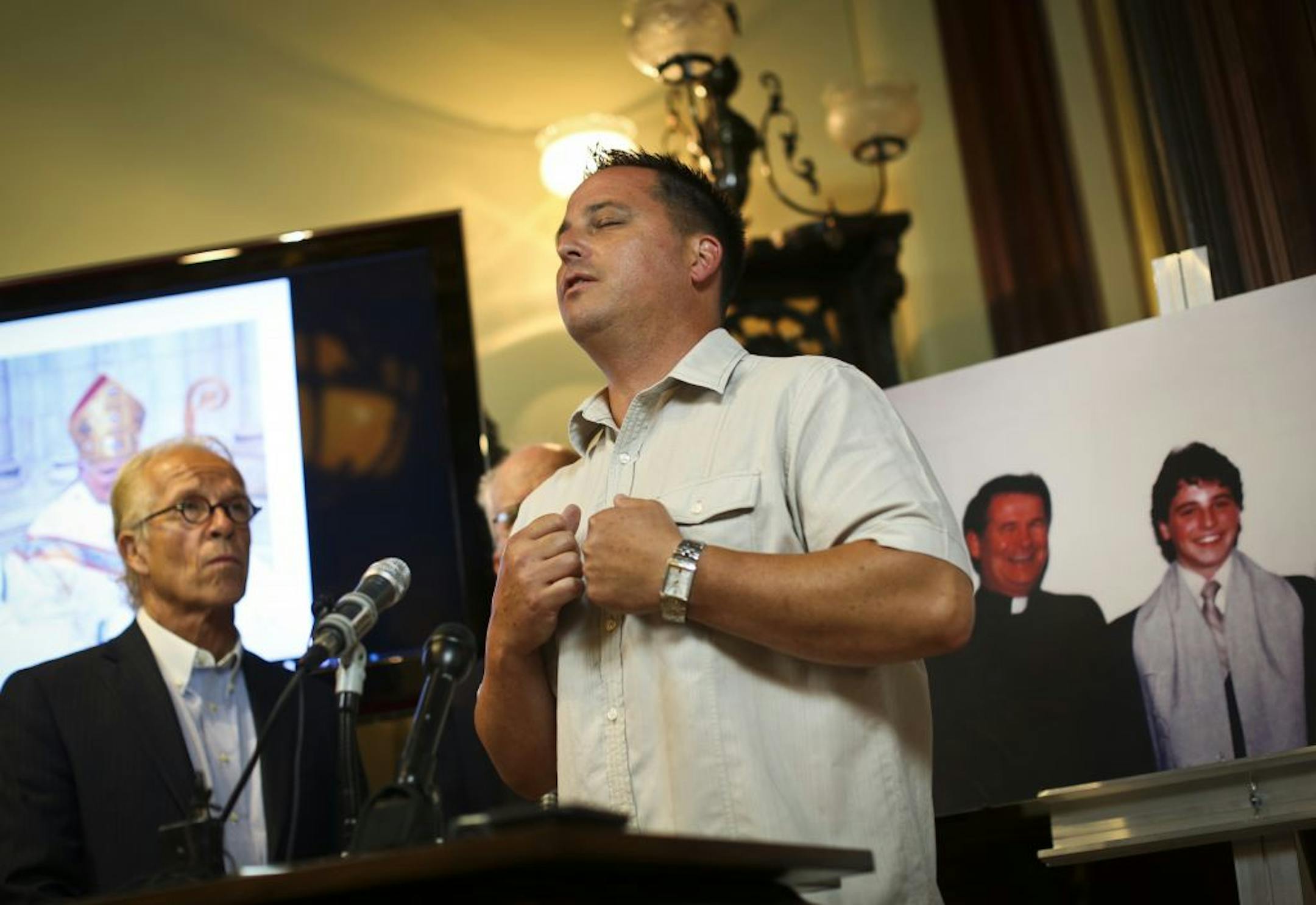 Jim Keenan, front, who had filed the lawsuit, discussed his frustration with the Catholic Church at the office of attorney Jeff Anderson, left.