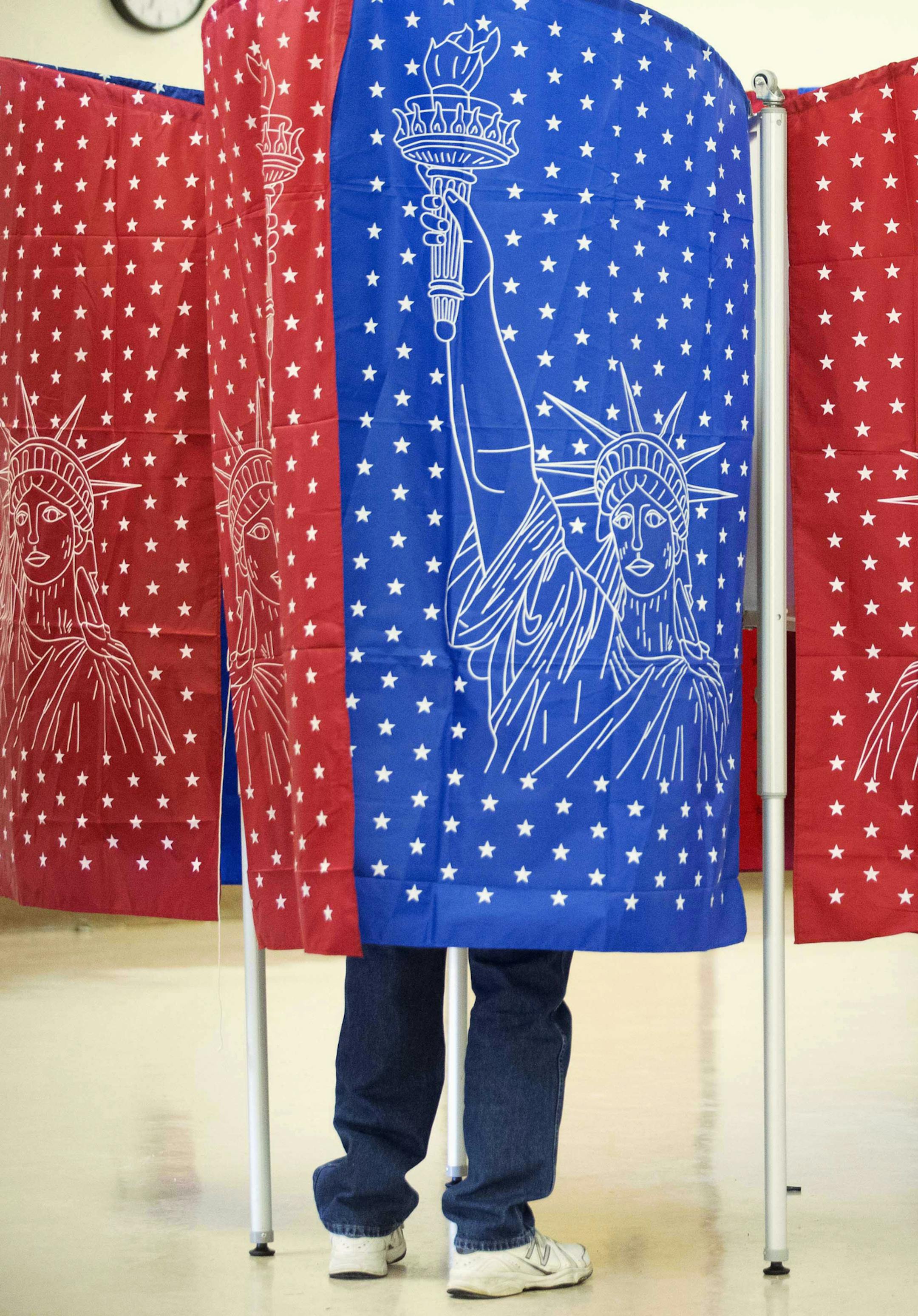 A voter marks a ballot for the New Hampshire primary inside a voting booth at a polling place Tuesday, Feb. 9, 2016, in Manchester, N.H. (AP Photo/David Goldman)