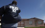An Immigration and Customs Enforcement officer outside a home in Calexico, Calif.