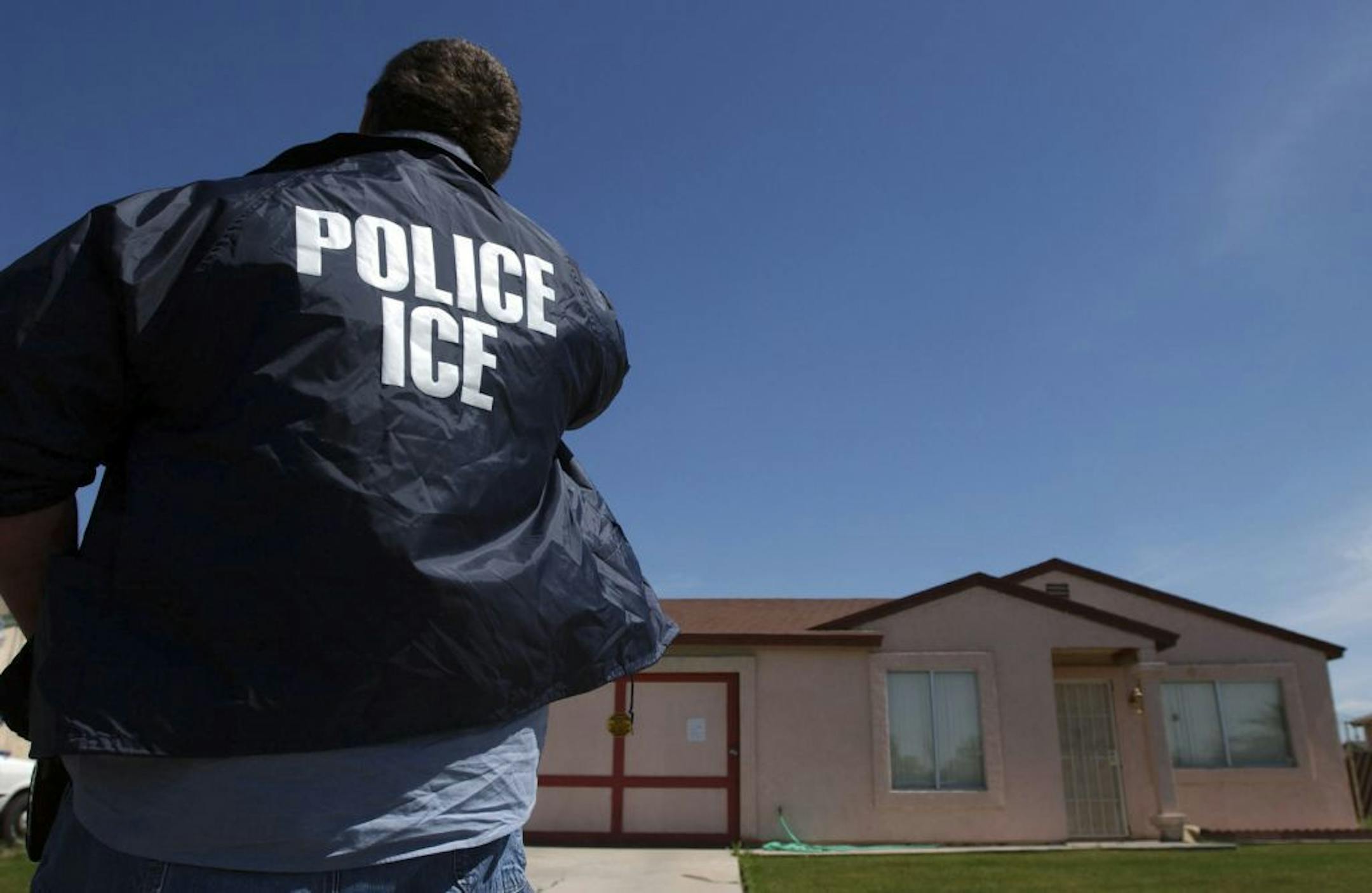 An Immigration and Customs Enforcement officer outside a home in Calexico, Calif.