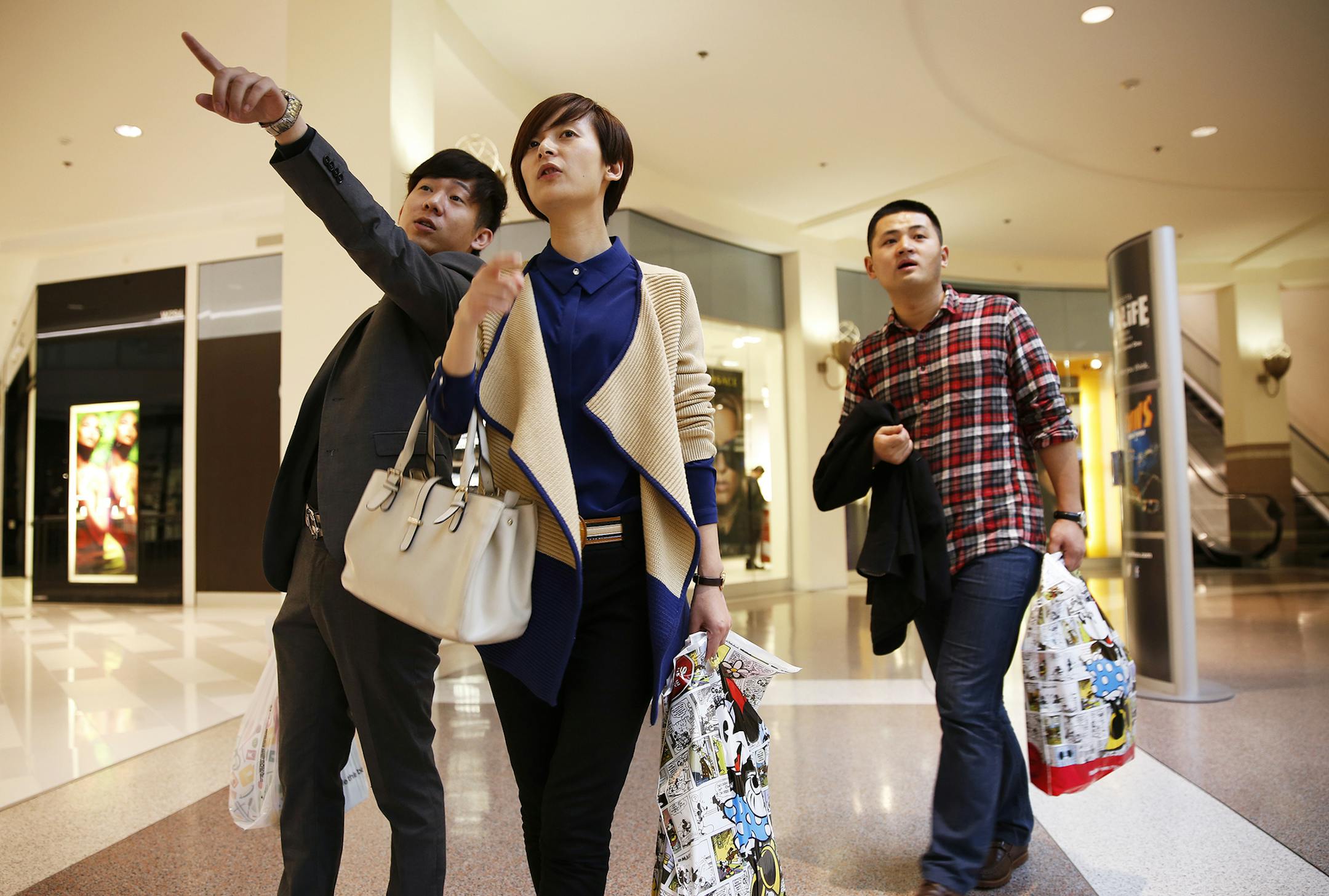 Lu Yan, center, gets some help from travel agent and guide Ming Jia of CIAC Travel while shopping with co-worker Yao Tao Tao, right, at Mall of America in Bloomington. Lu Yan and Yao Tao Tao are both from China and in town for a trade show. ] LEILA NAVIDI leila.navidi@startribune.com / BACKGROUND INFORMATION: Monday, October 13, 2014. The Mall of America is honing in on China as a key market for attracting new shoppers in the next decade. It has hired a marketing firm in China to plug the mall a