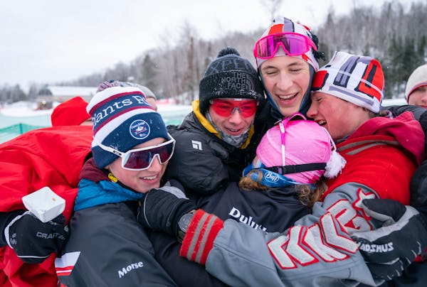 Duluth East nordic skiers Colin Willemsen and James Kyes are swarmed by their teammates after taking first place in the boy's team sprint final during