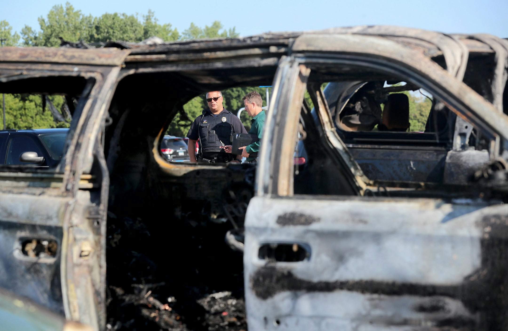 A car fire at a Fridley Walmart engulfed three vehicles and left two young passengers injured in a taxi van parked next to the vehicle where the fire originated Tuesday, Aug. 6, 2019, in Fridley, MN. Here, law enforcement officers investigated the scene.