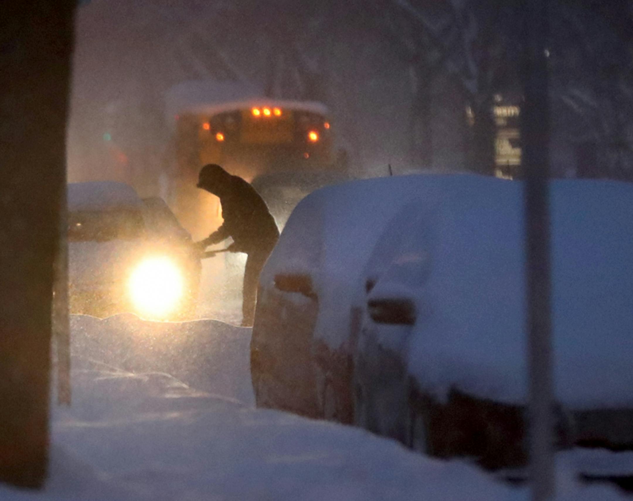 A motorist clears his car off Tuesday on Park Ave. South near Franklin Ave. South In Minneapolis.
