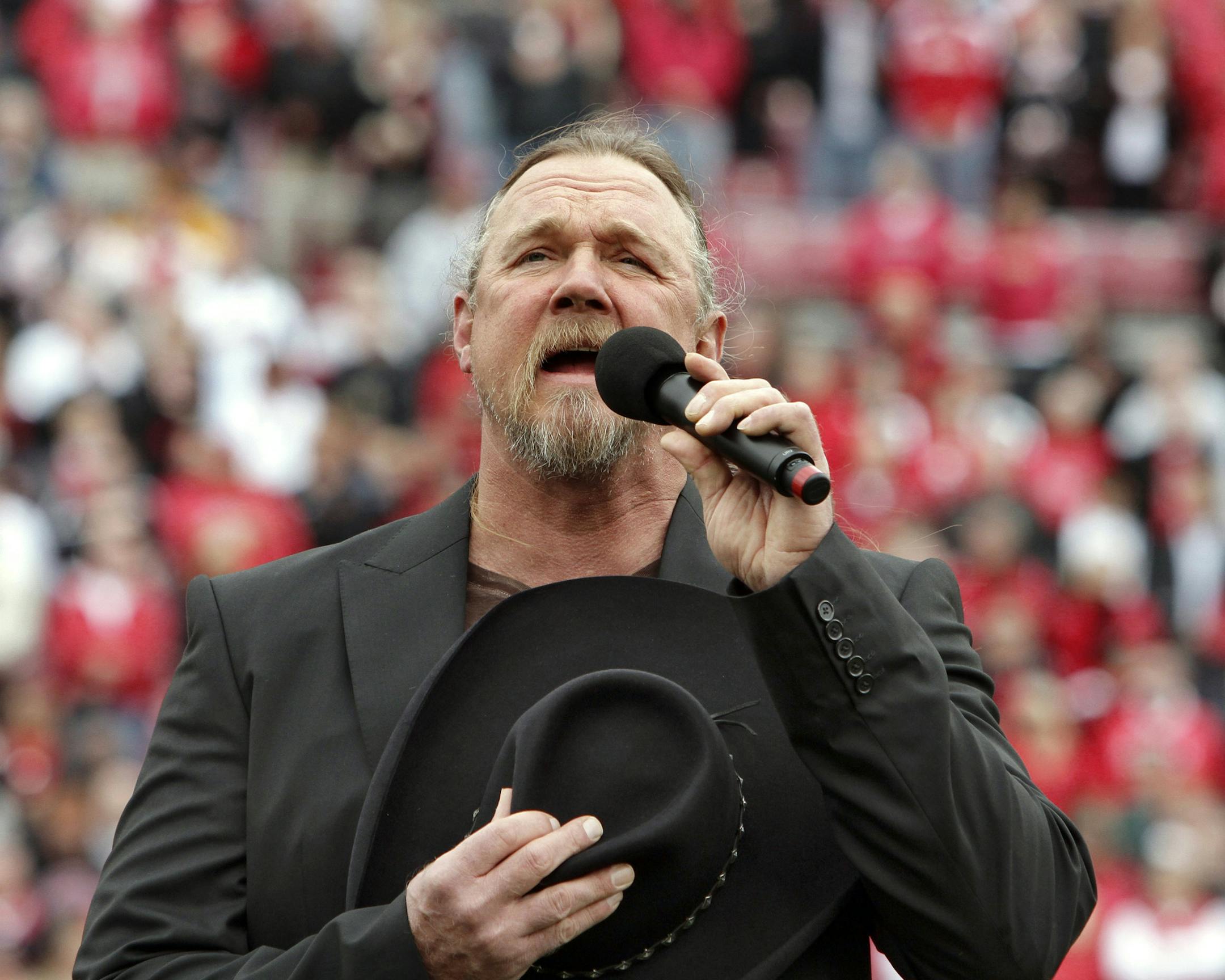 Country music artist Trace Adkins signs the national anthem before the start of the Marshall-Louisville NCAA college football game in Louisville, Ky., Saturday, Oct. 1, 2011. (AP Photo/Garry Jones) ORG XMIT: NYOTK