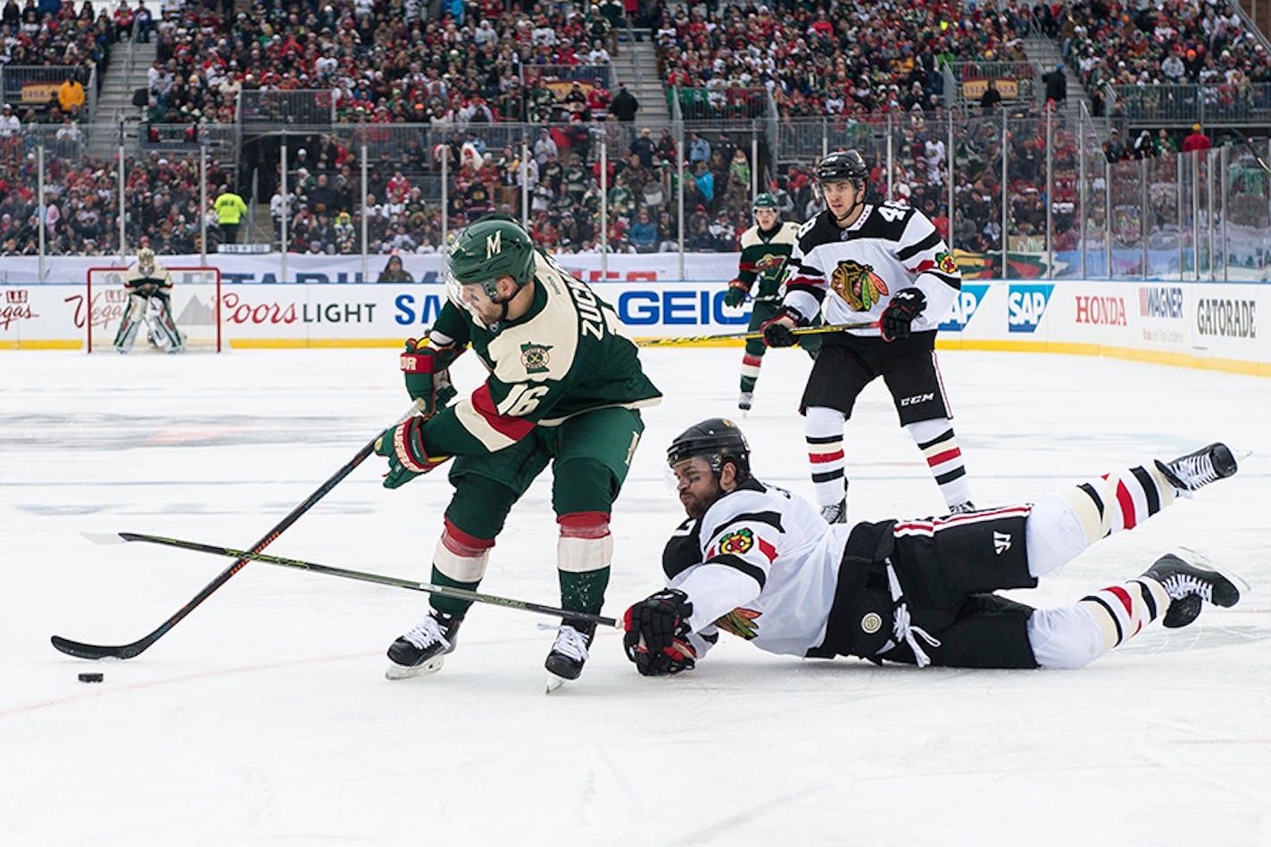 Chicago Blackhawks defenseman Brent Seabrook (7) fell to the ice while trying to steal the puck from Minnesota Wild left wing Jason Zucker (16) in the first period at TCF Bank Stadium.