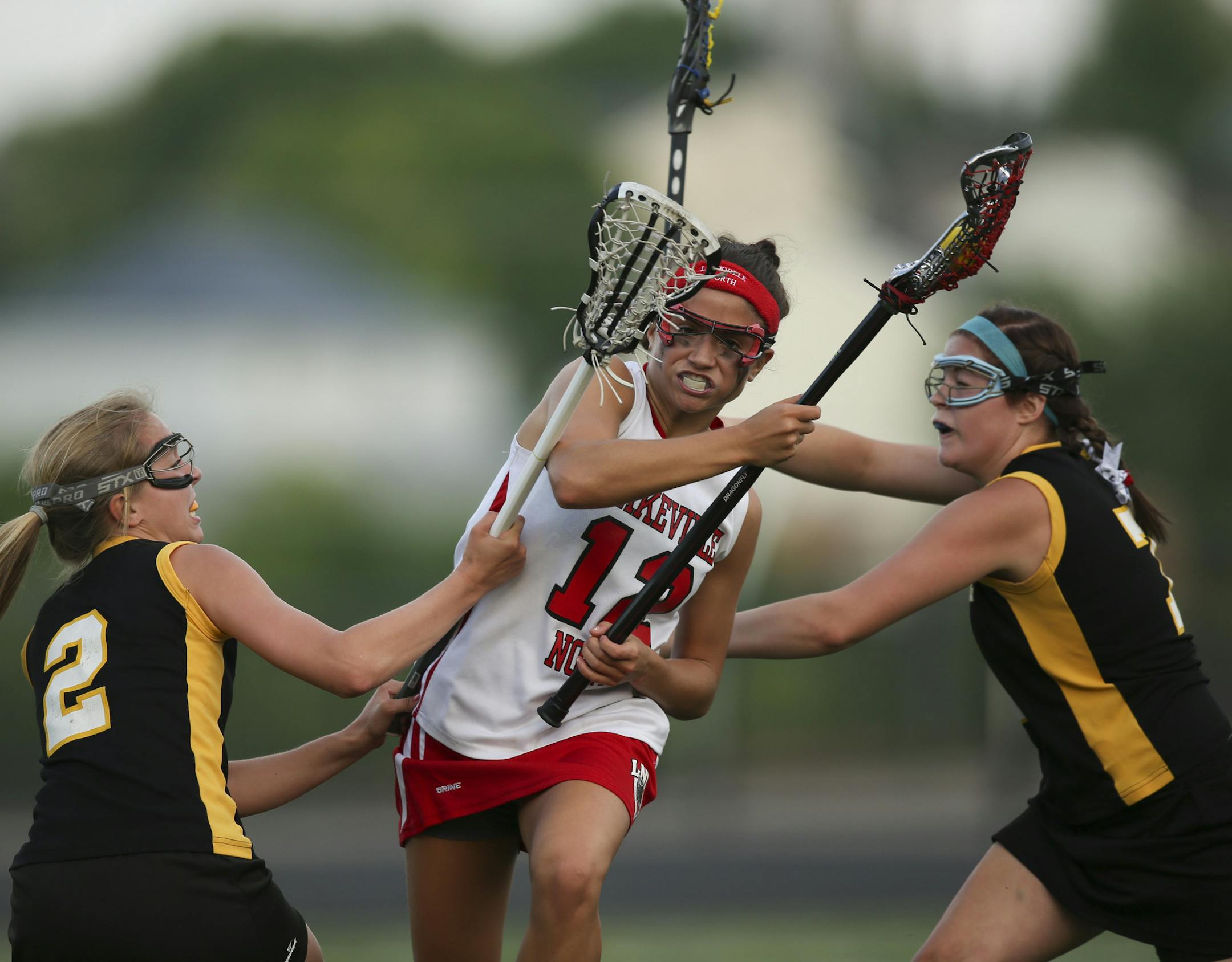 Lakeville North’s Hannah Koloski plowed through the defense set up by Burnsville’s Samanthan Vikstrom, left, and Bailey Childs as she drove to the net in the first half Tuesday at Chanhassen High School. The Panthers beat the Blaze 16-12.